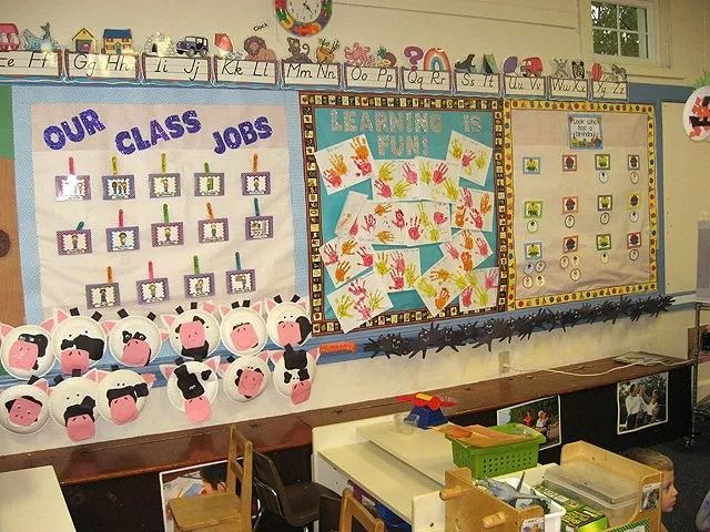Classroom bulletin boards with “Our Class Jobs,” colorful charts, and animal crafts displayed above cubbies