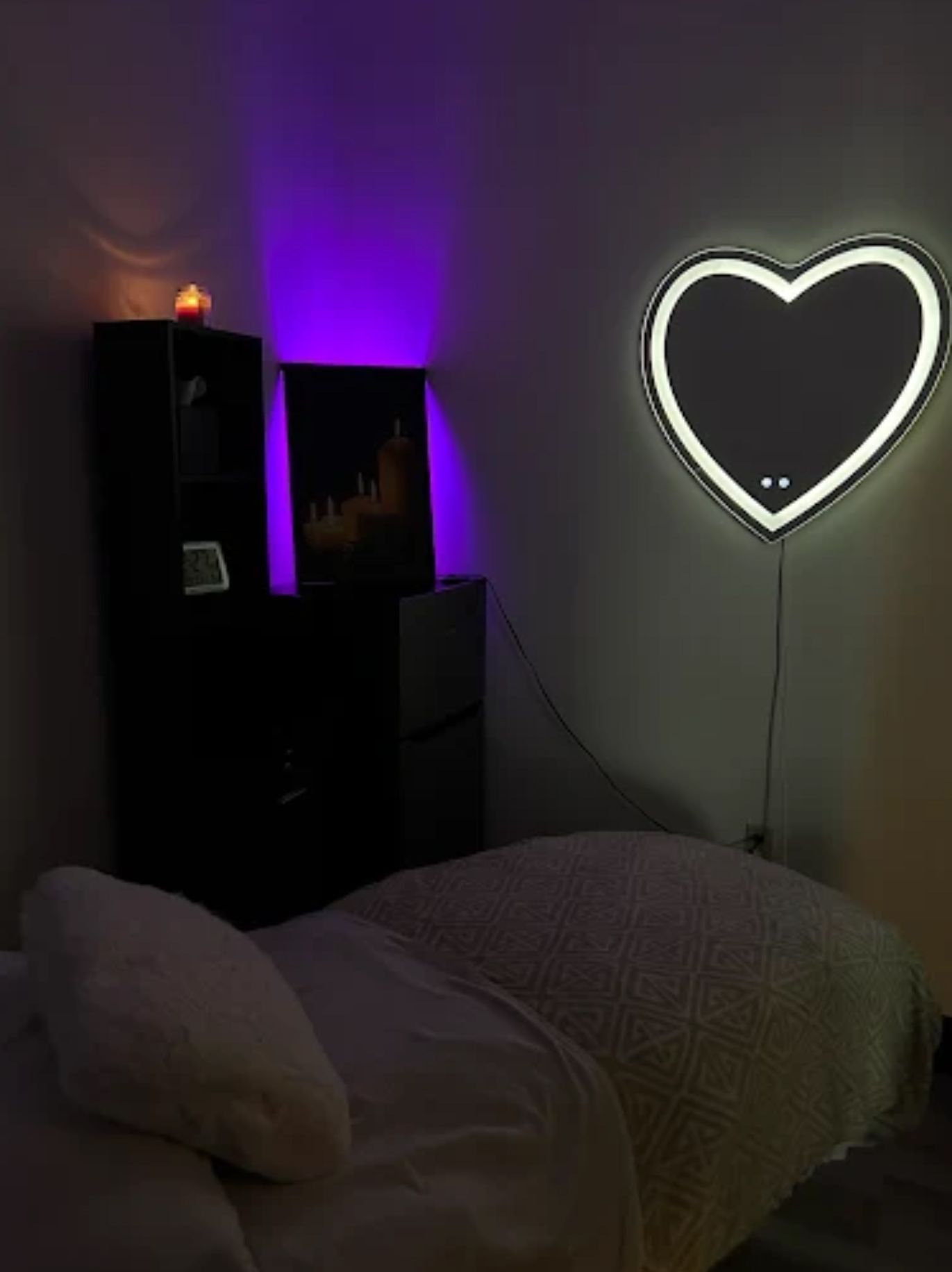 Massage room with heart-shaped light, black storage, and purple accent lighting.