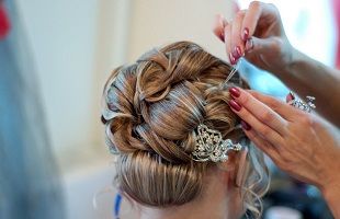 A woman is getting her hair done by a hairdresser in a salon.