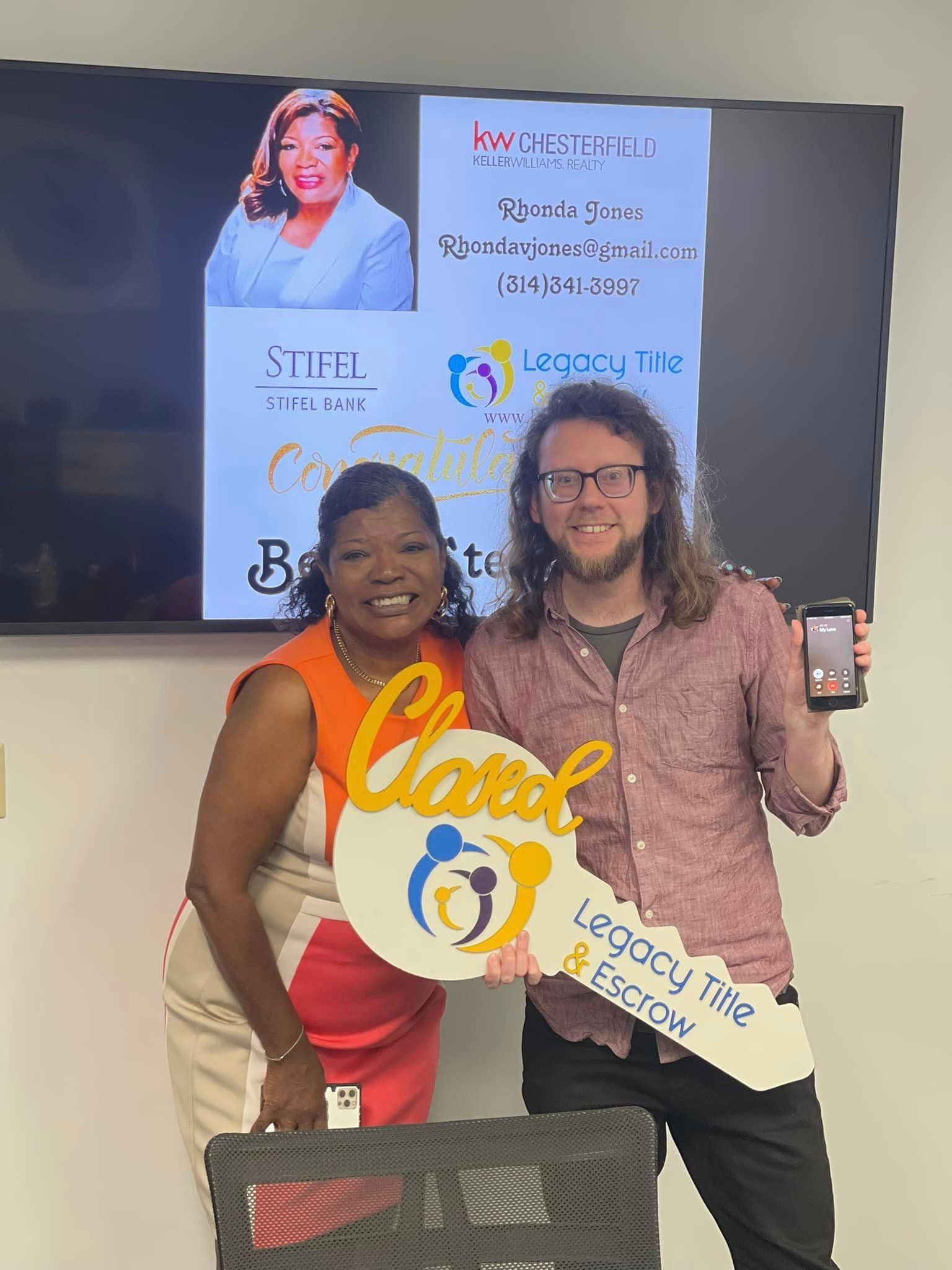A man and a woman are standing next to each other holding a sign.