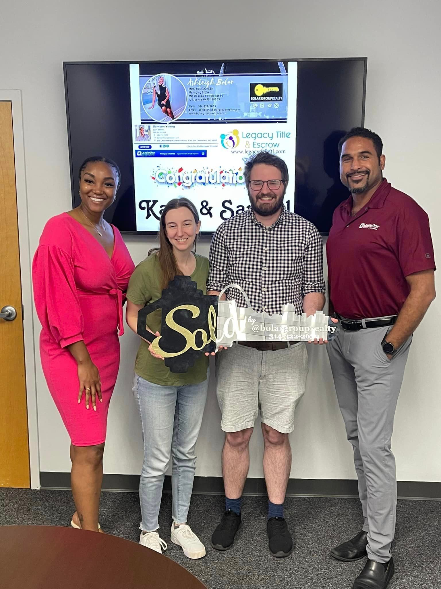 A group of people are standing next to each other in front of a television.