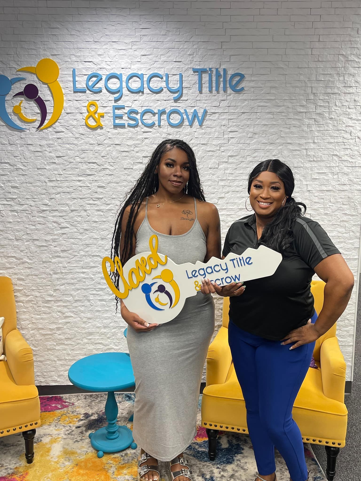 Two women are standing next to each other holding a large key.