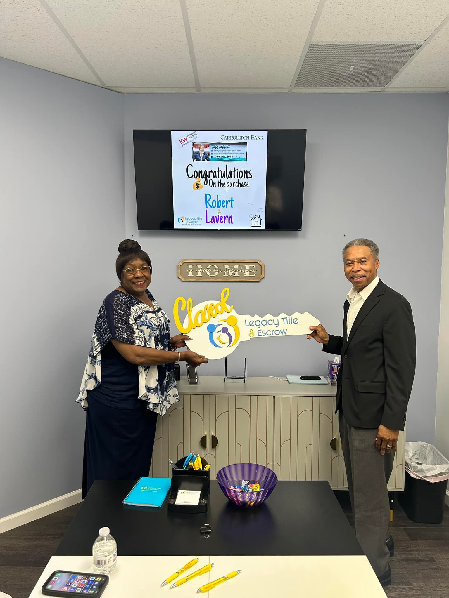 A man is giving a key to a woman in a room.