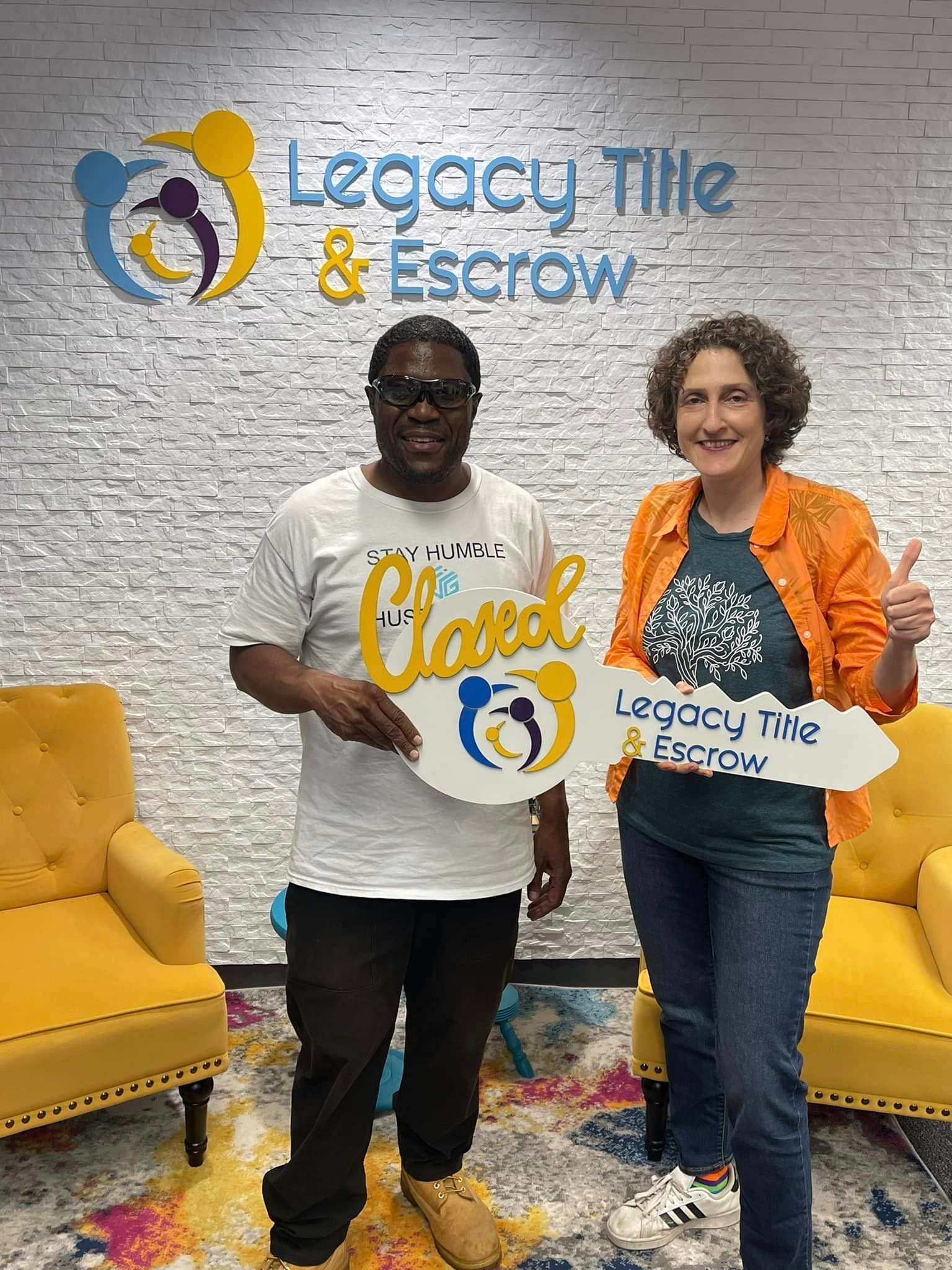 A man and a woman are standing next to each other in a room holding signs.