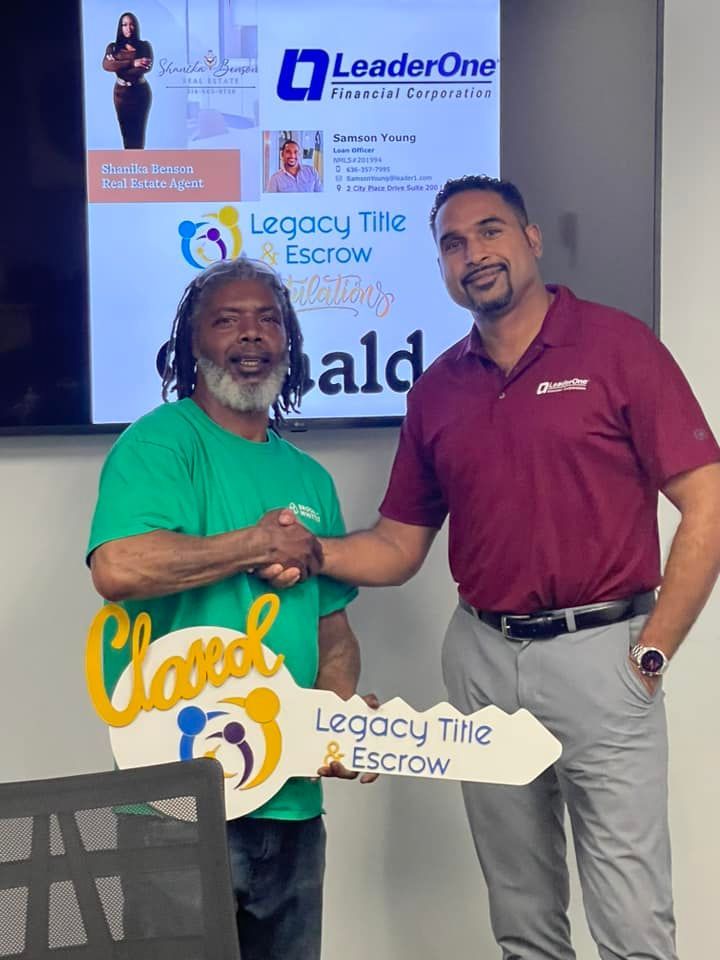 Two men shaking hands in front of a legacy title escrow sign