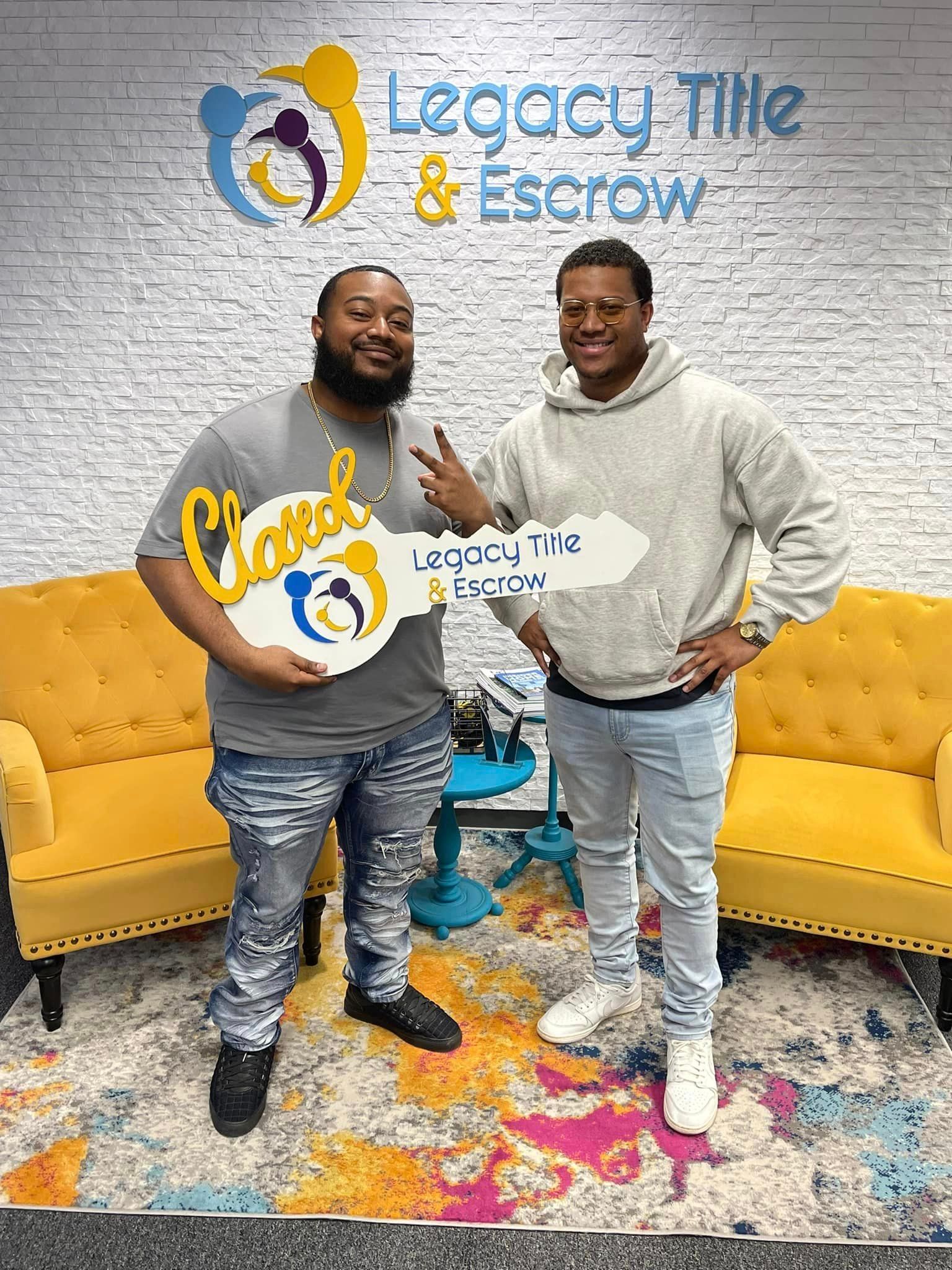 Two men are standing next to each other in a room holding a key.