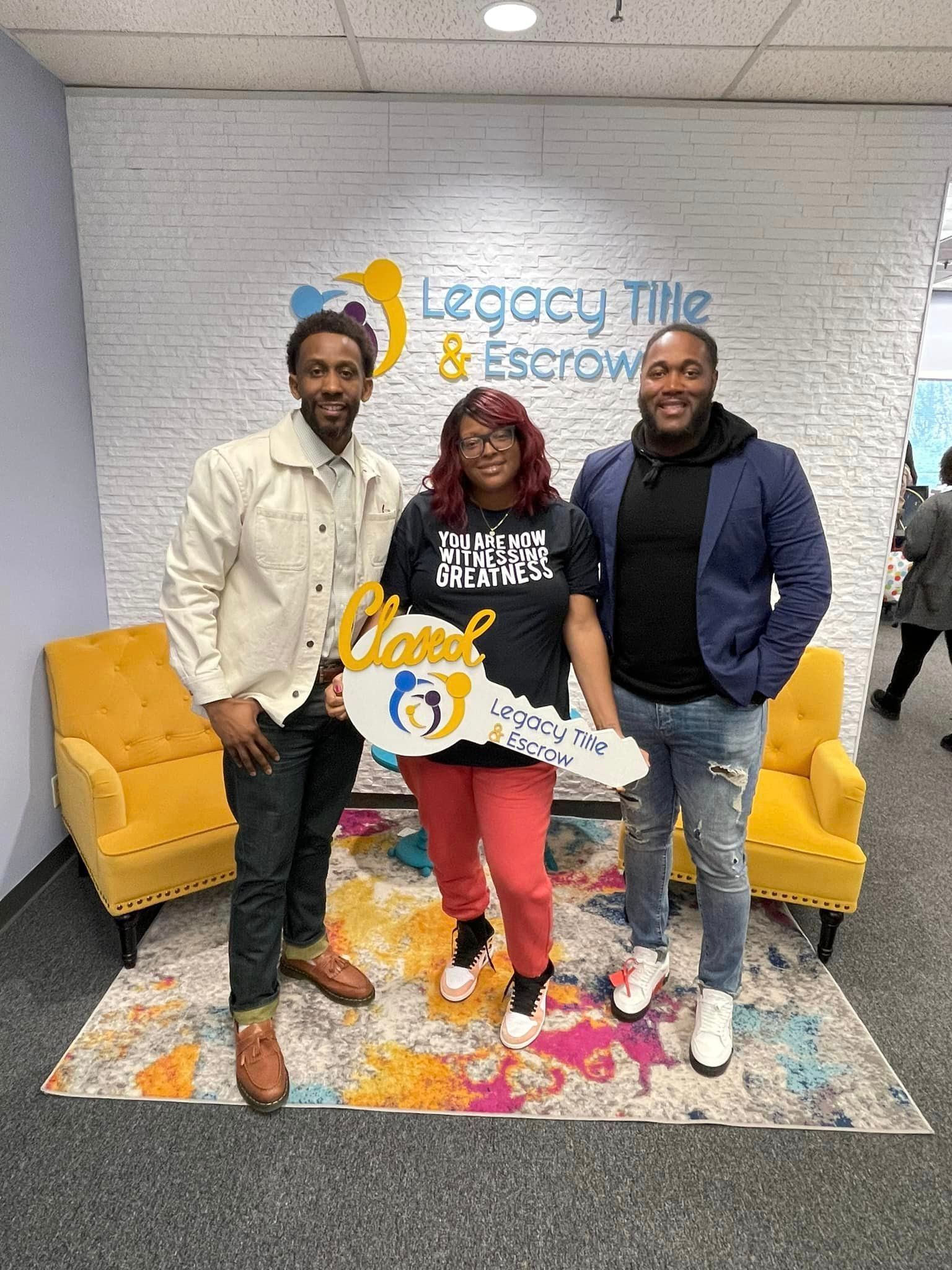 A group of people are standing next to each other in a room holding a key.