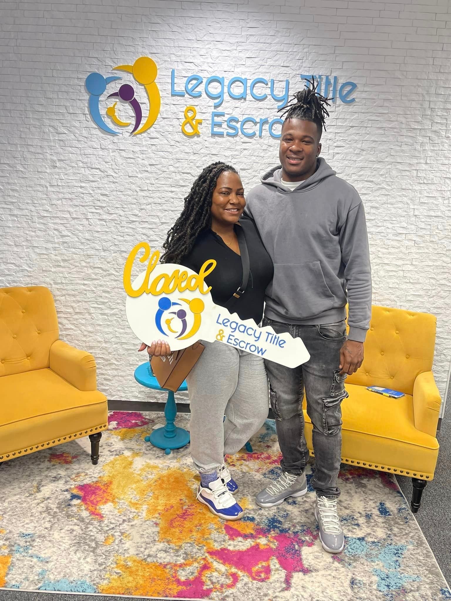 A man and a woman are standing next to each other holding a large key.