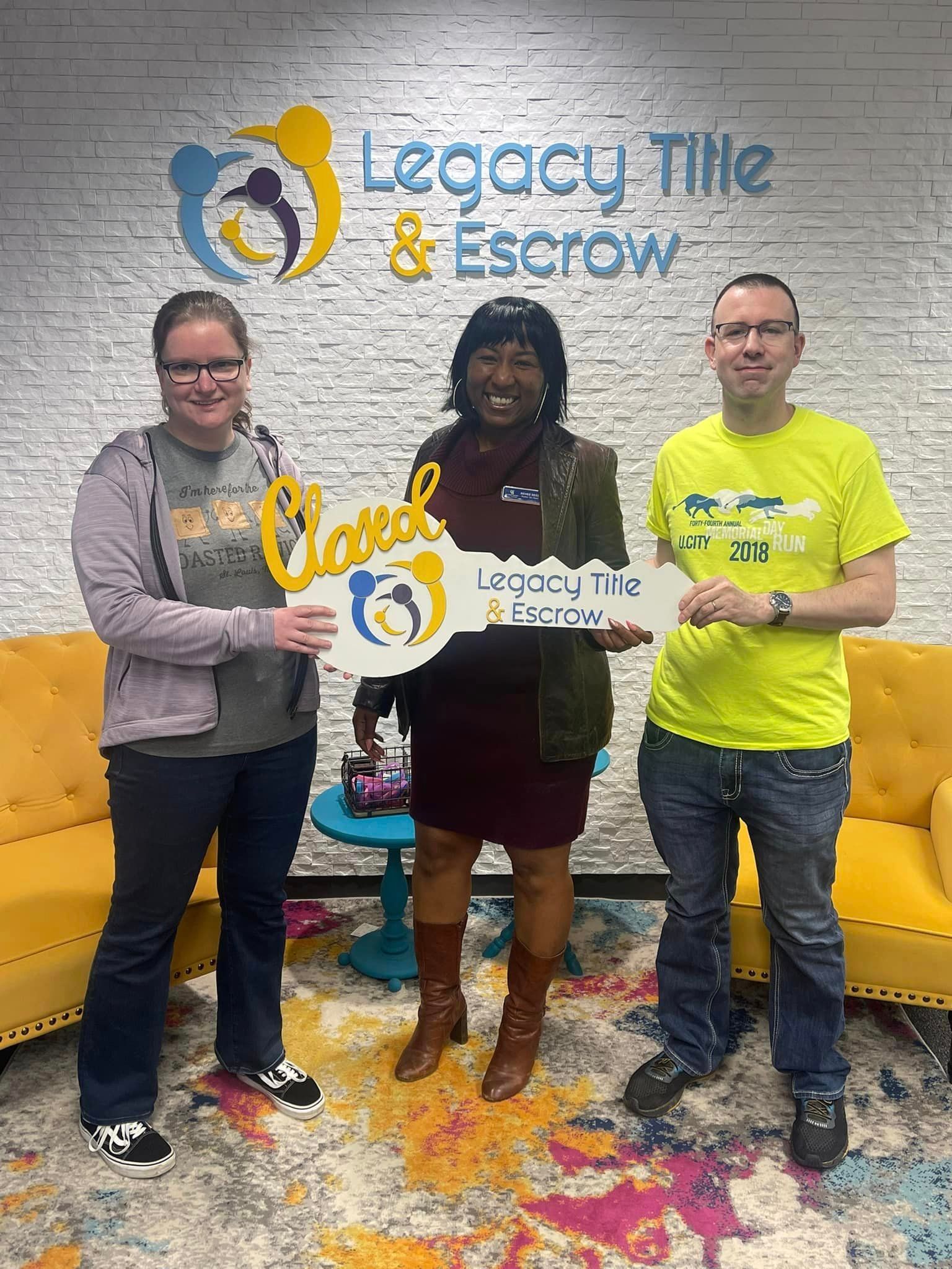 A group of people are standing next to each other holding a large key.