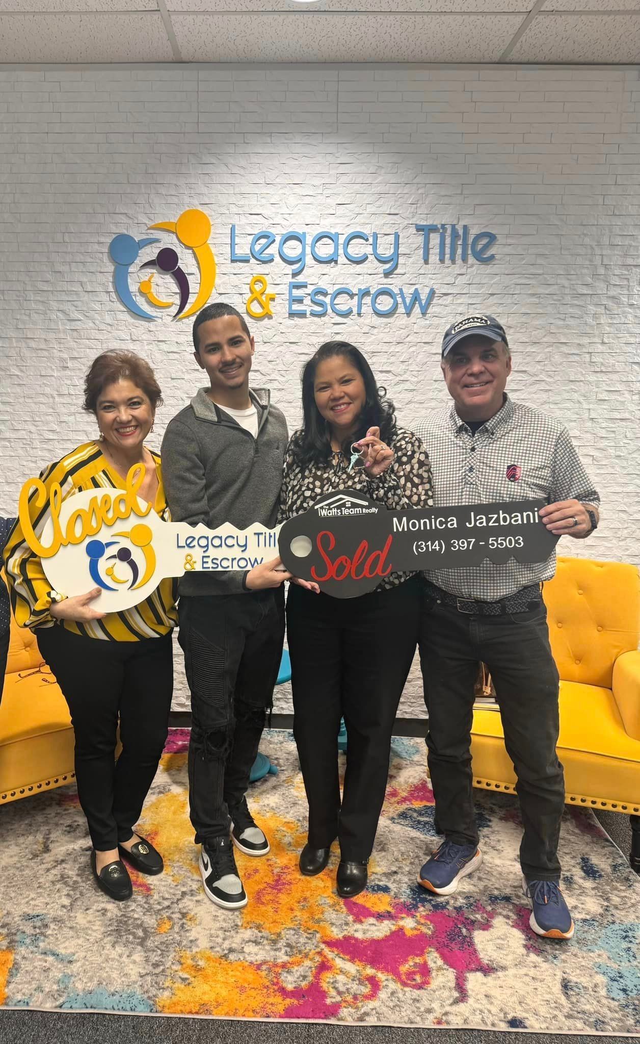 A group of people standing next to each other holding keys in front of a brick wall.