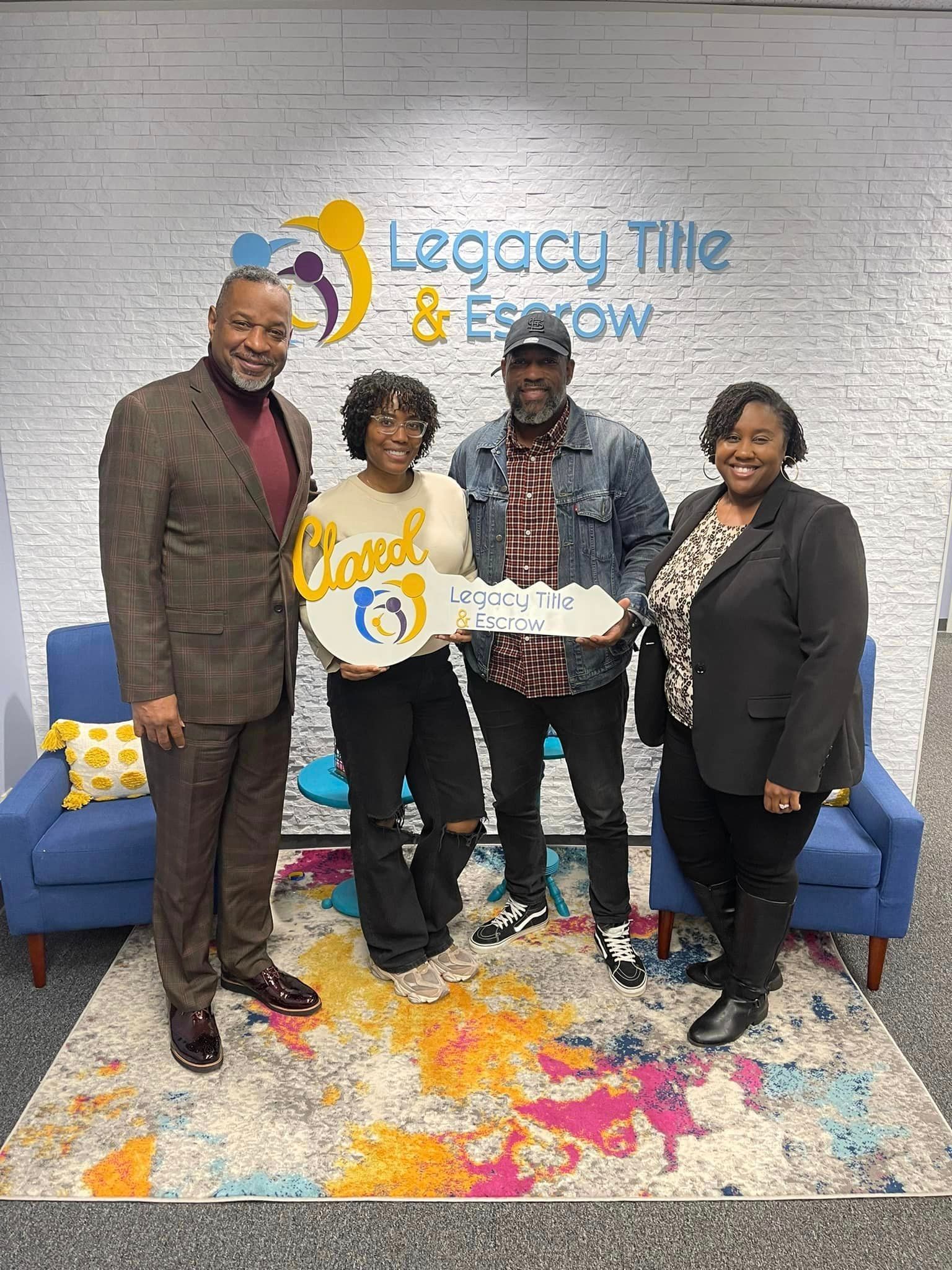 A group of people standing next to each other in front of a brick wall holding keys.