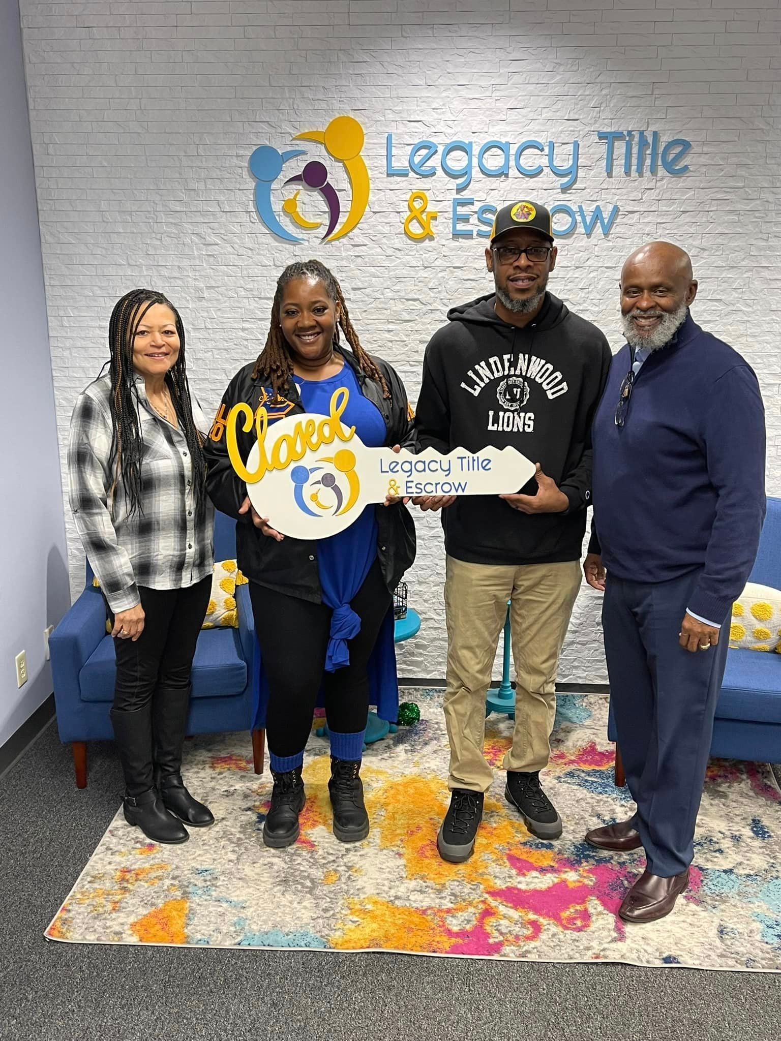 A group of people are standing next to each other in a room holding a key.