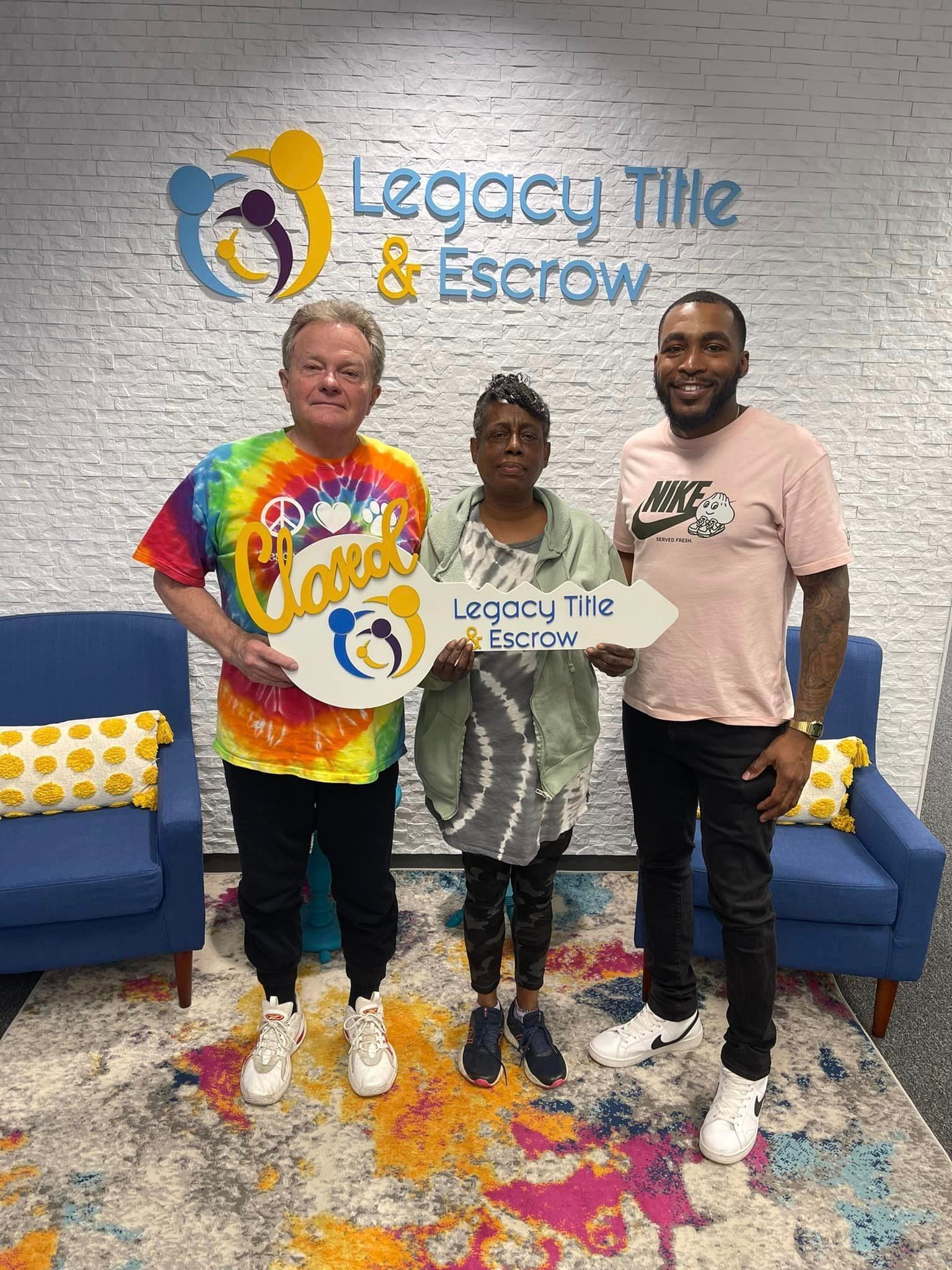 Three people are standing next to each other in a room holding signs.