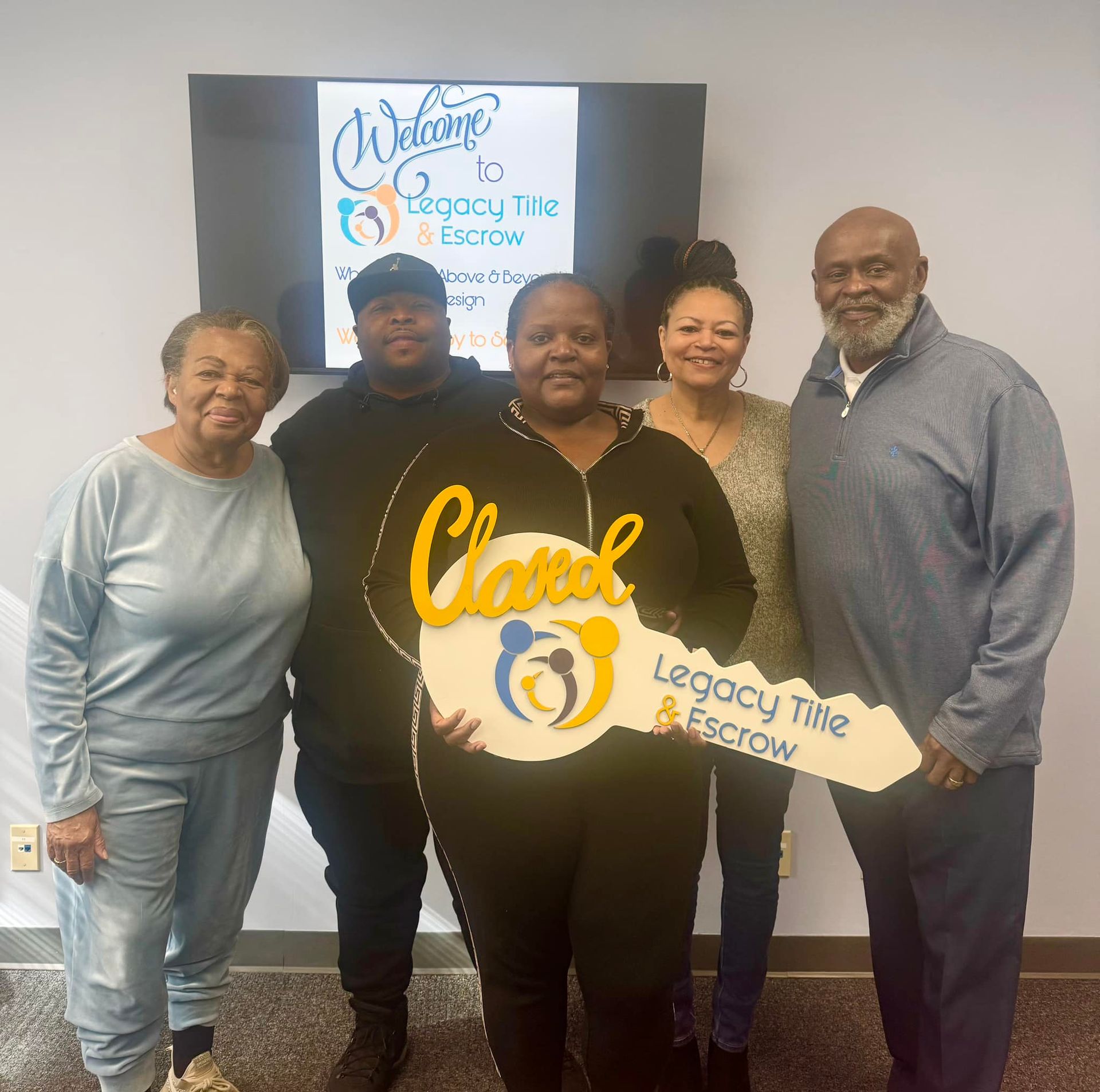A group of people standing in front of a sign that says welcome