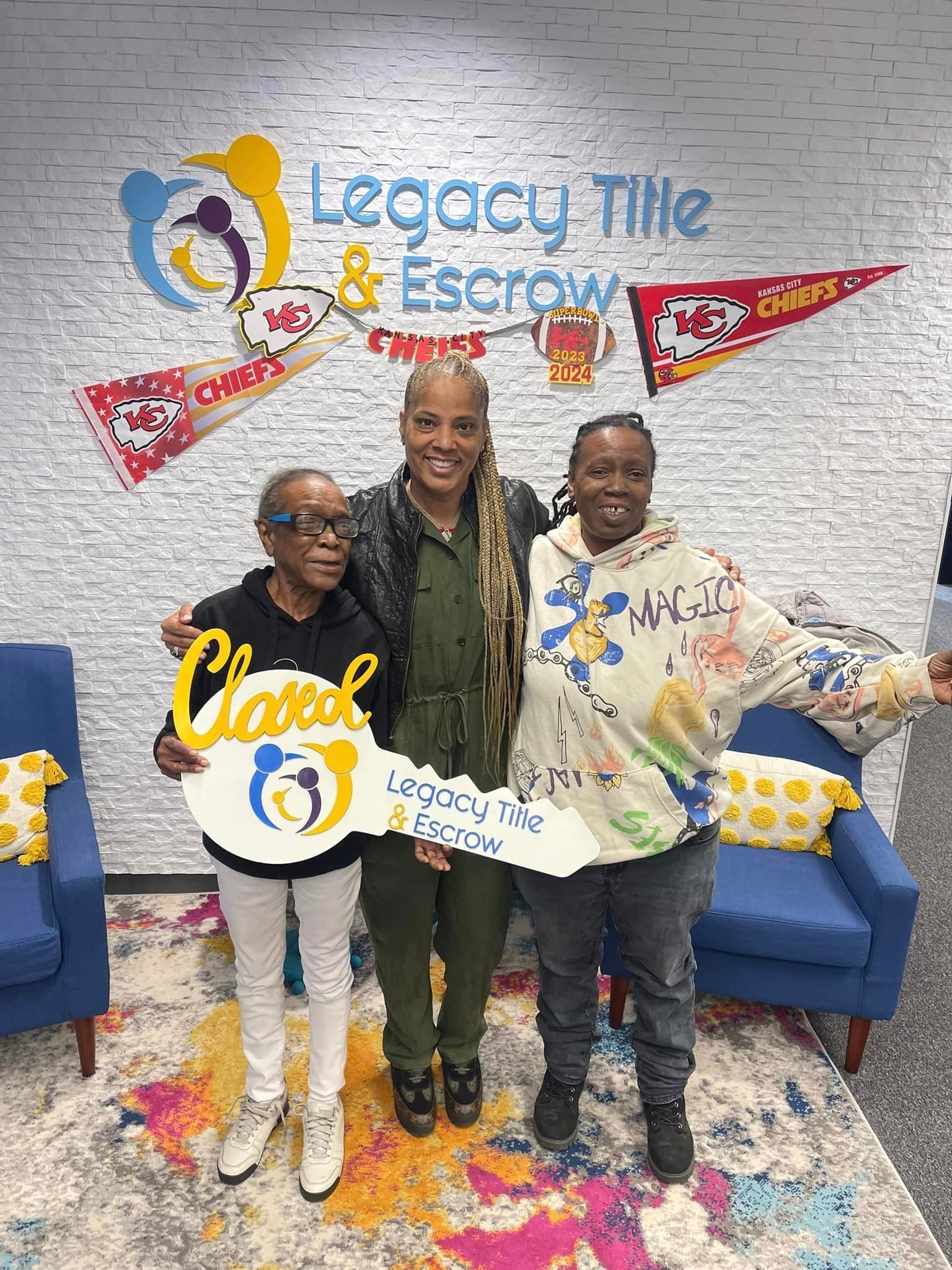 Three women are standing next to each other in a room holding keys.