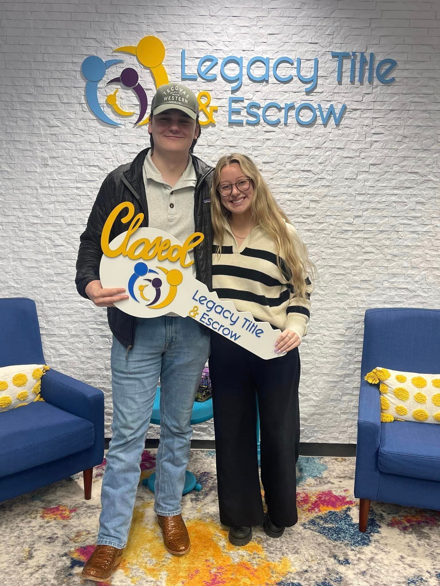 A man and a woman are standing next to each other holding a key.