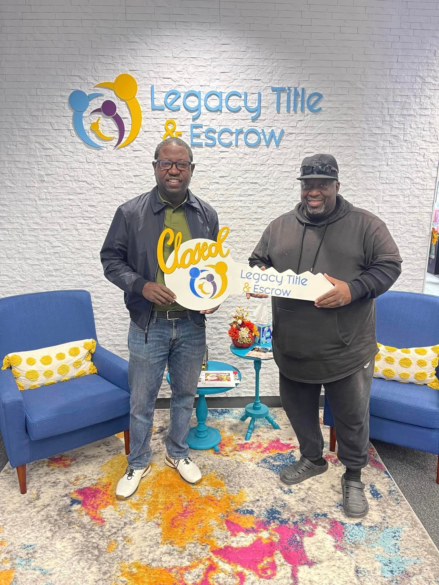 Two men are standing next to each other in a room holding signs.