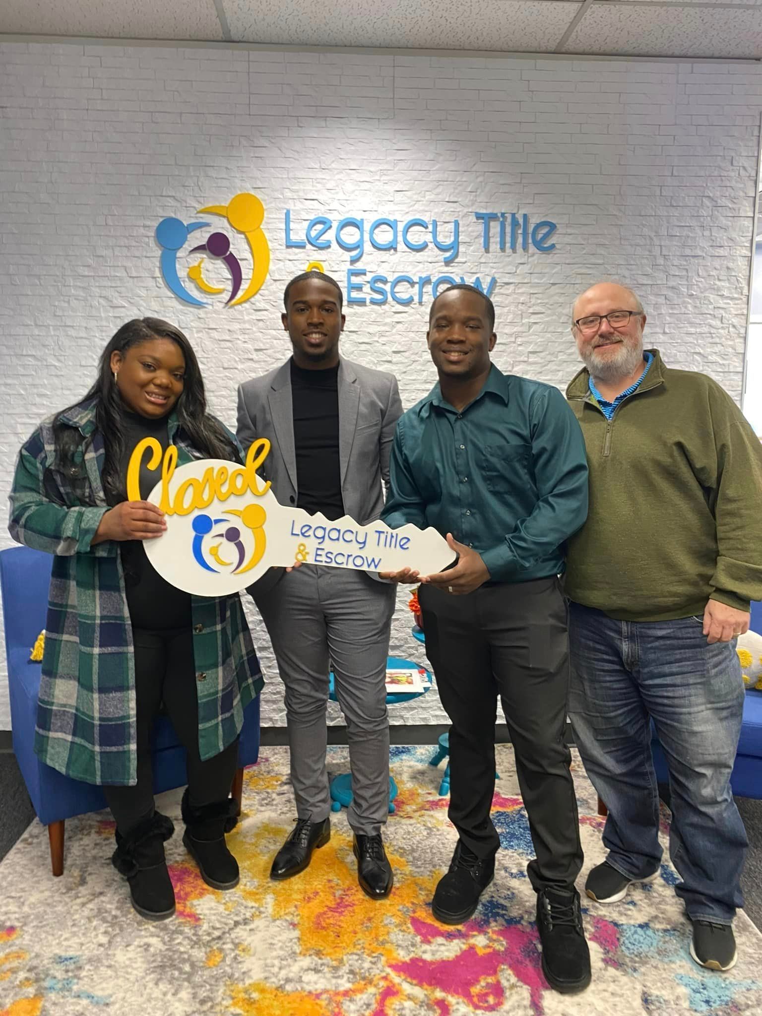 A group of people standing next to each other holding a key.