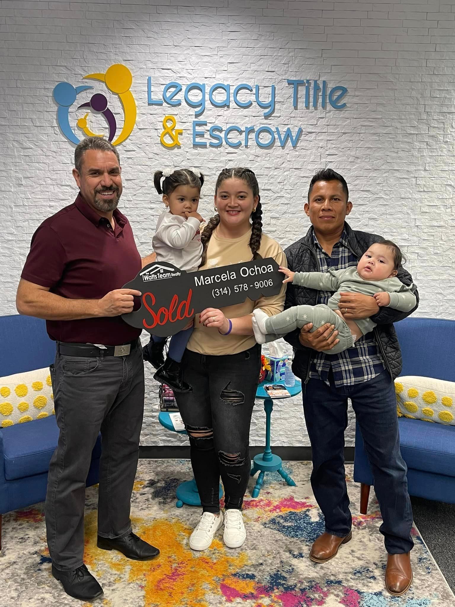 A group of people standing next to each other in front of a brick wall.