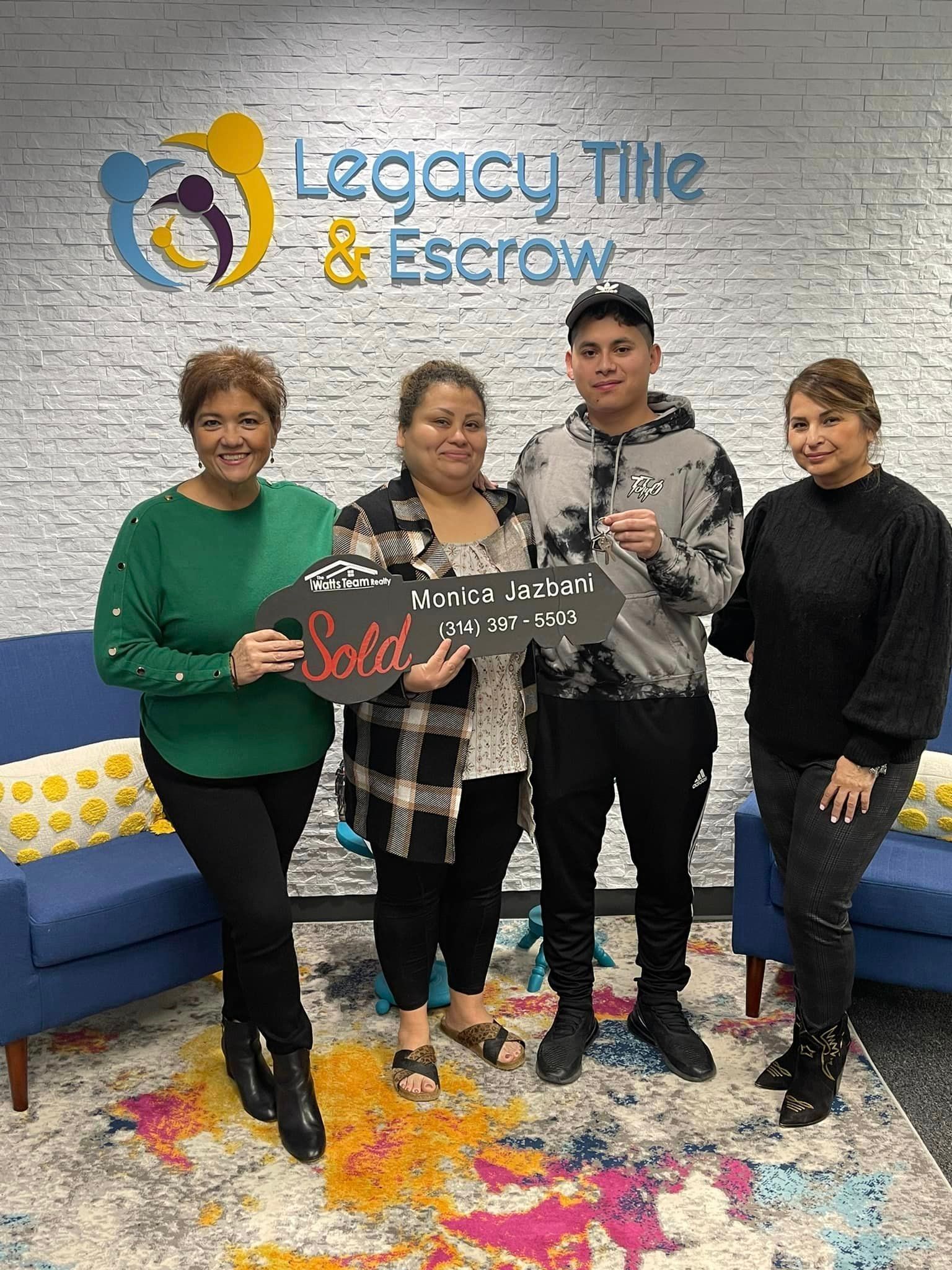 A group of people standing next to each other holding a sign that says `` sold ''.