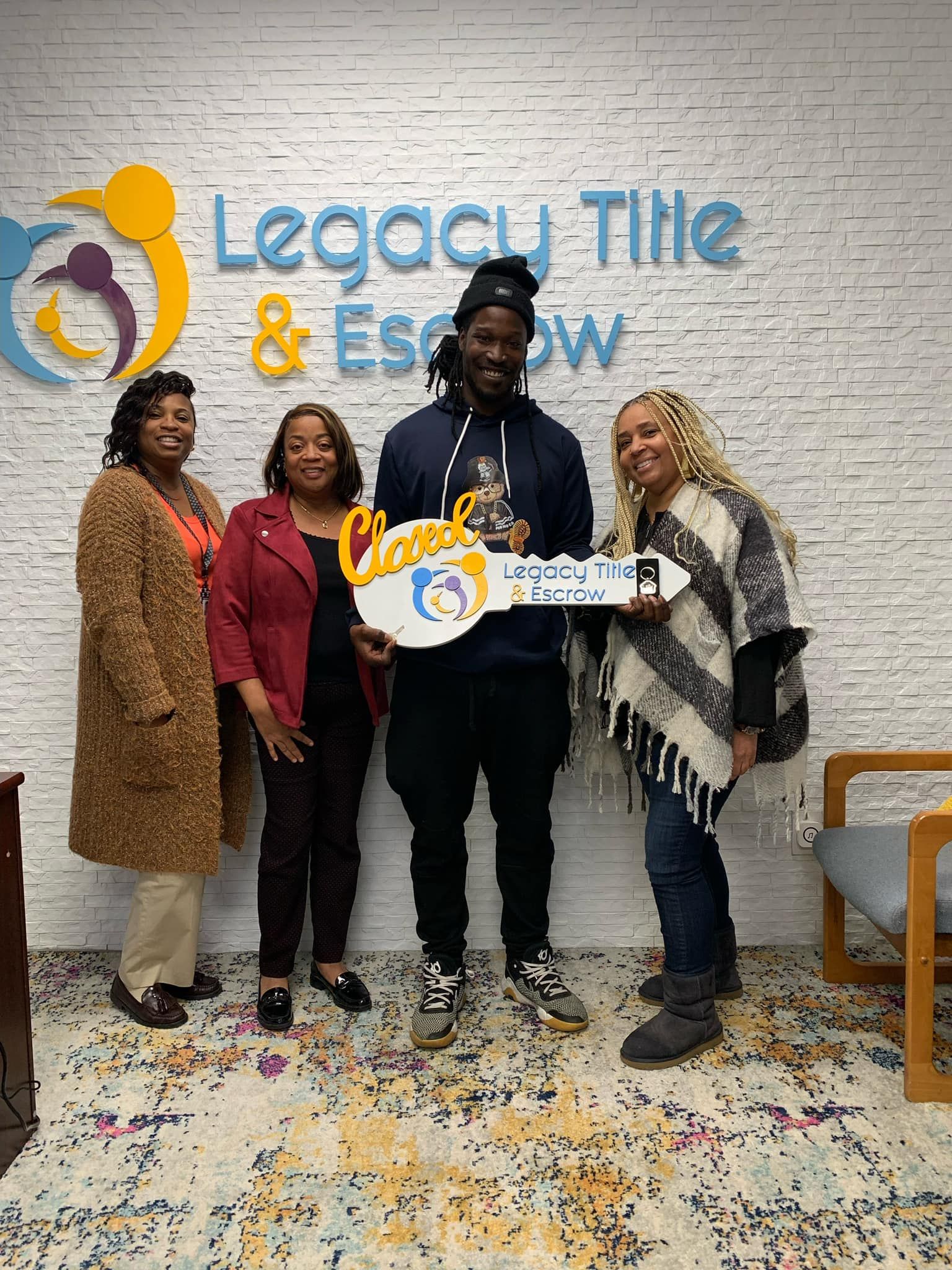 A group of people are standing next to each other holding a key.