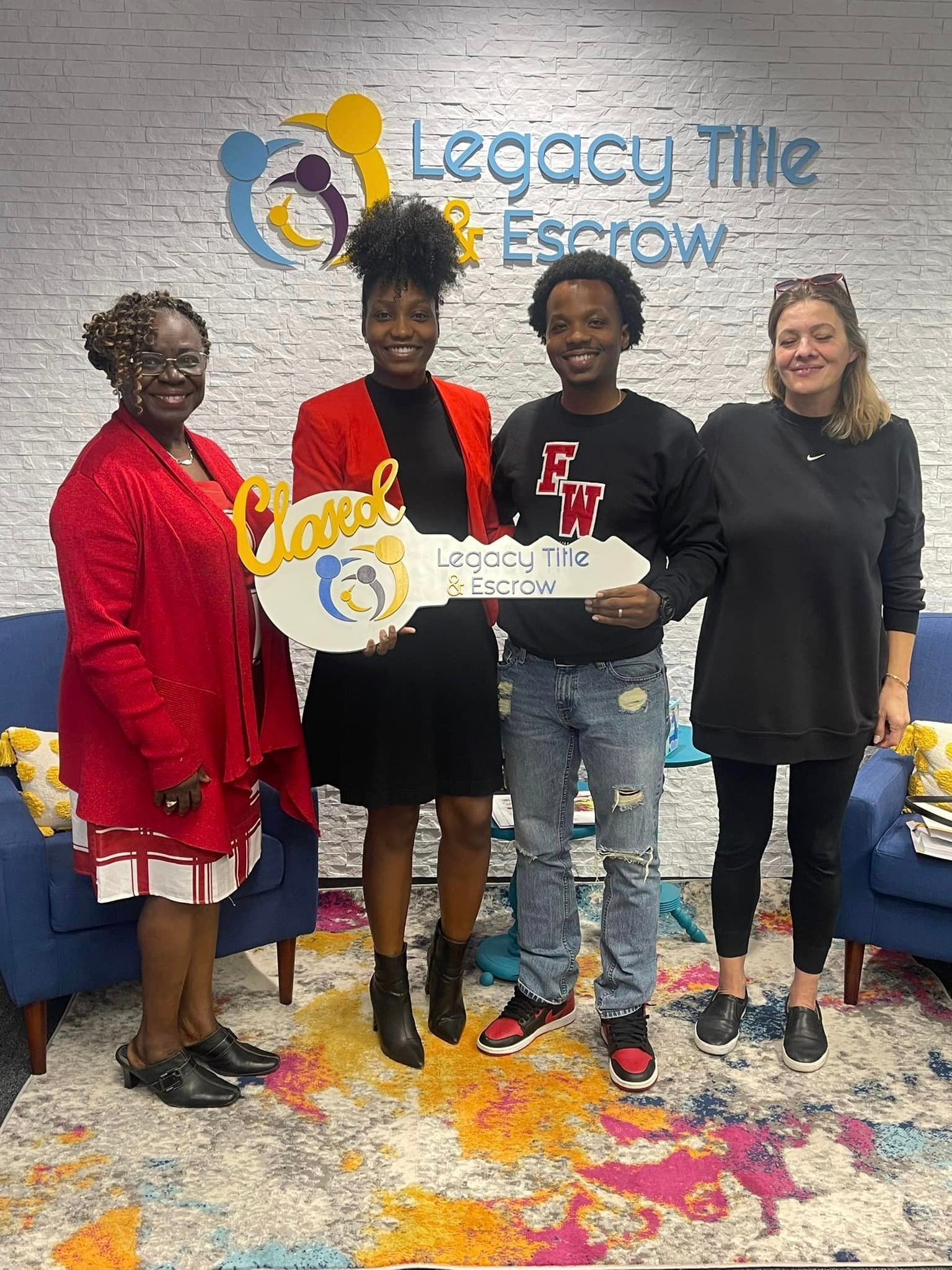 A group of people standing next to each other in front of a brick wall holding keys.