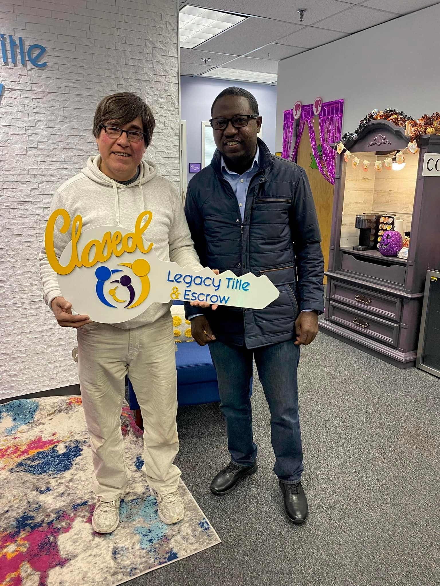 Two men are standing next to each other in a room holding signs.