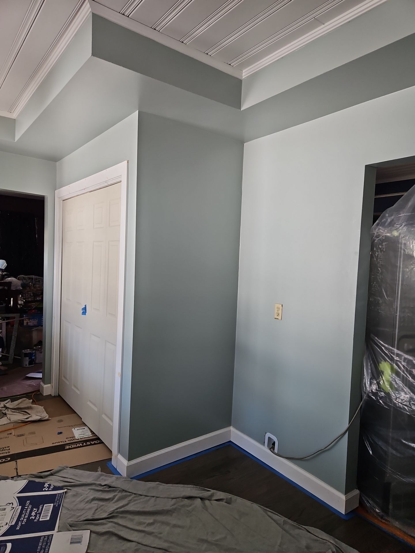 Room corner painted two shades of green, white trim, with closet and ceiling detail.