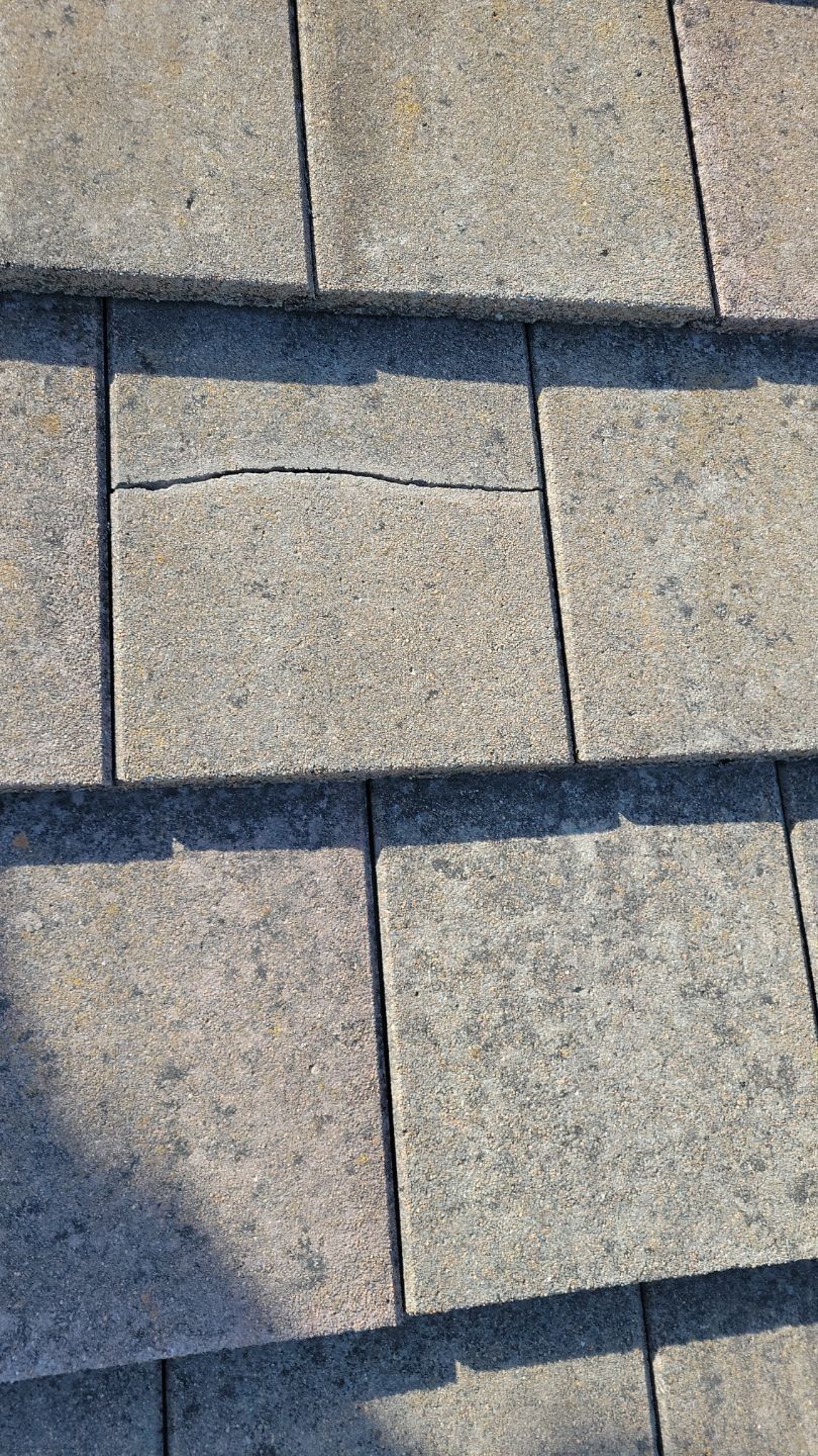 Close-up of a cracked, gray roof shingle.