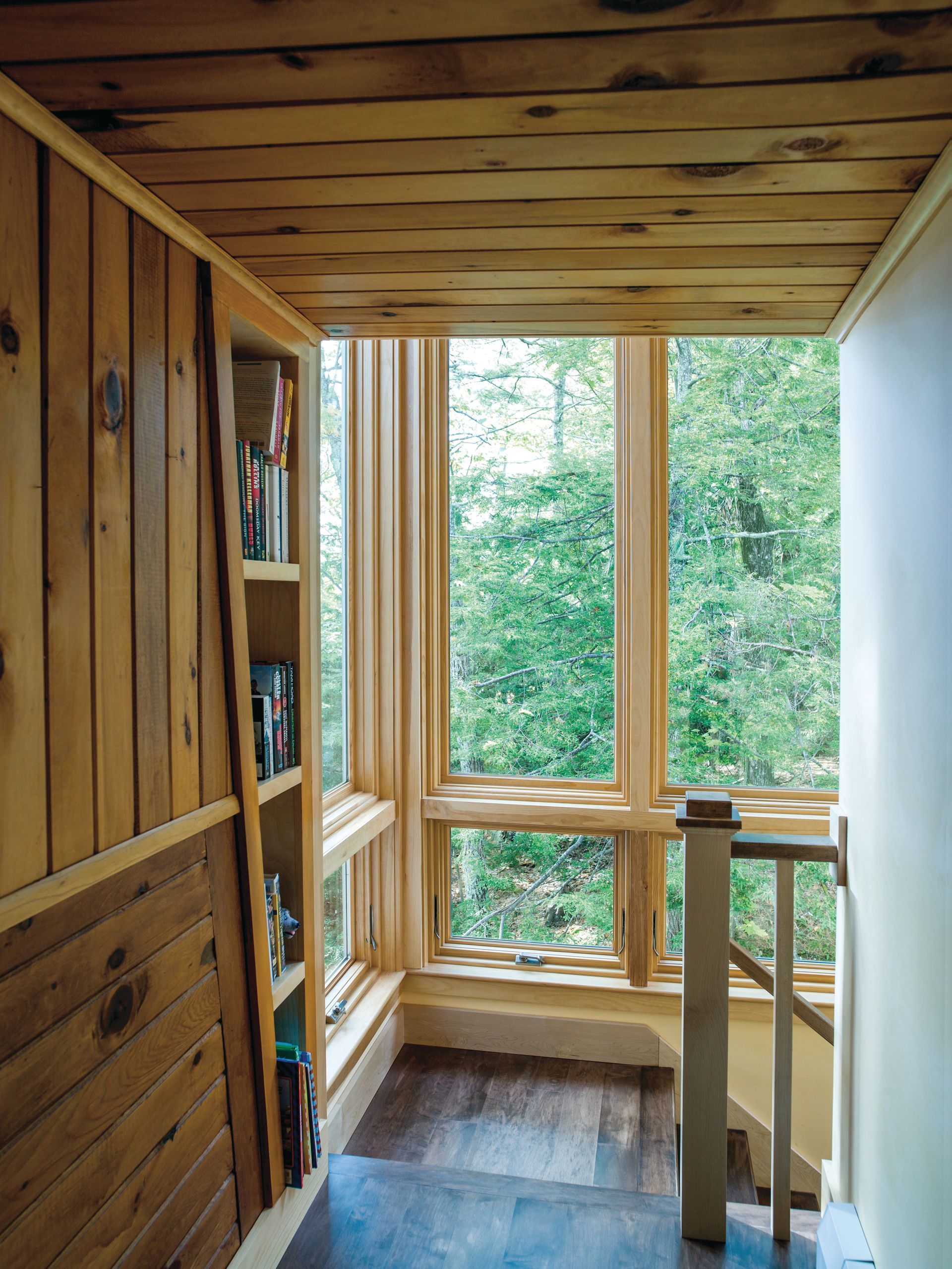 A hallway with a staircase and a large window