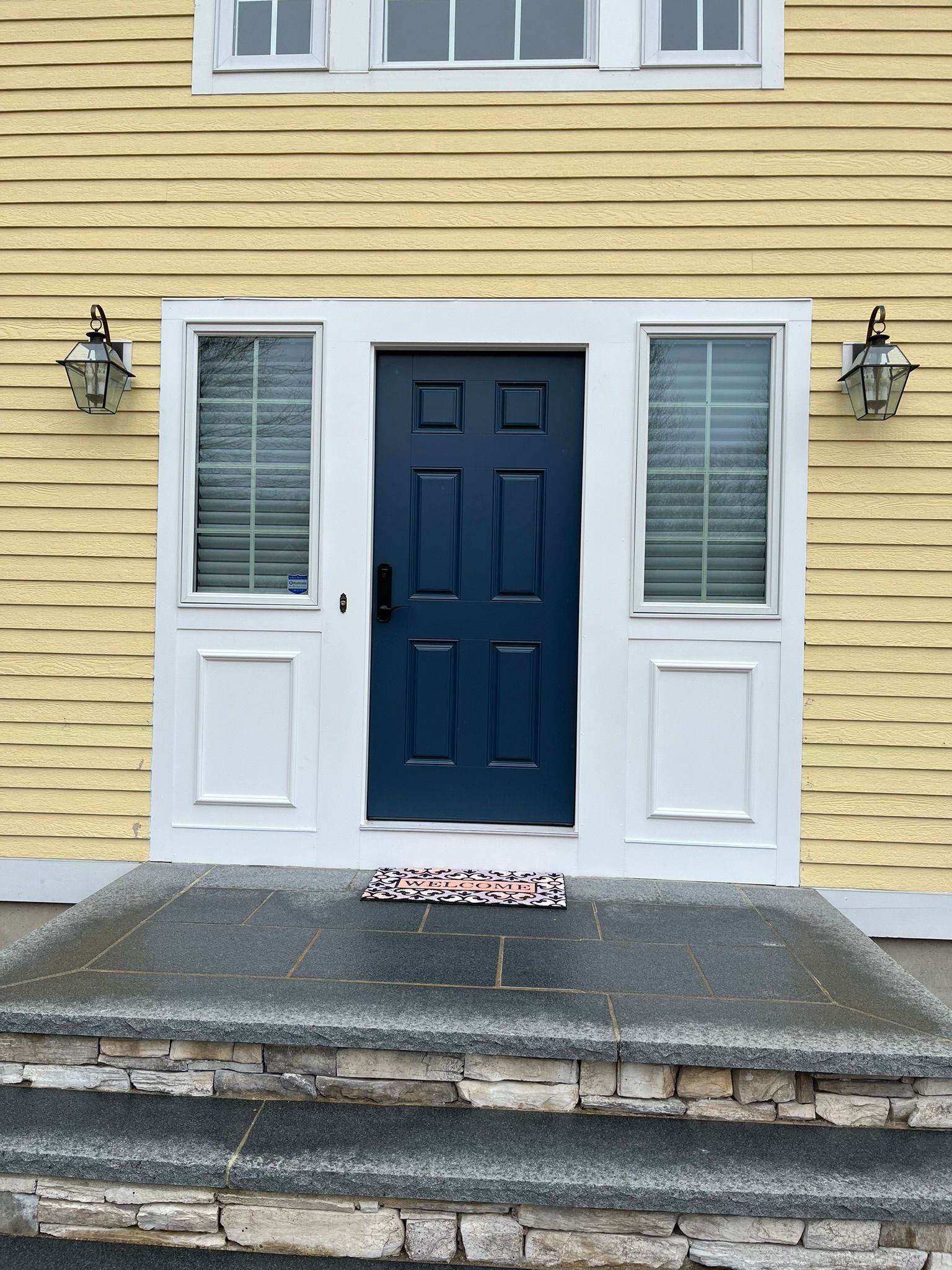 A yellow house with a blue door and white trim