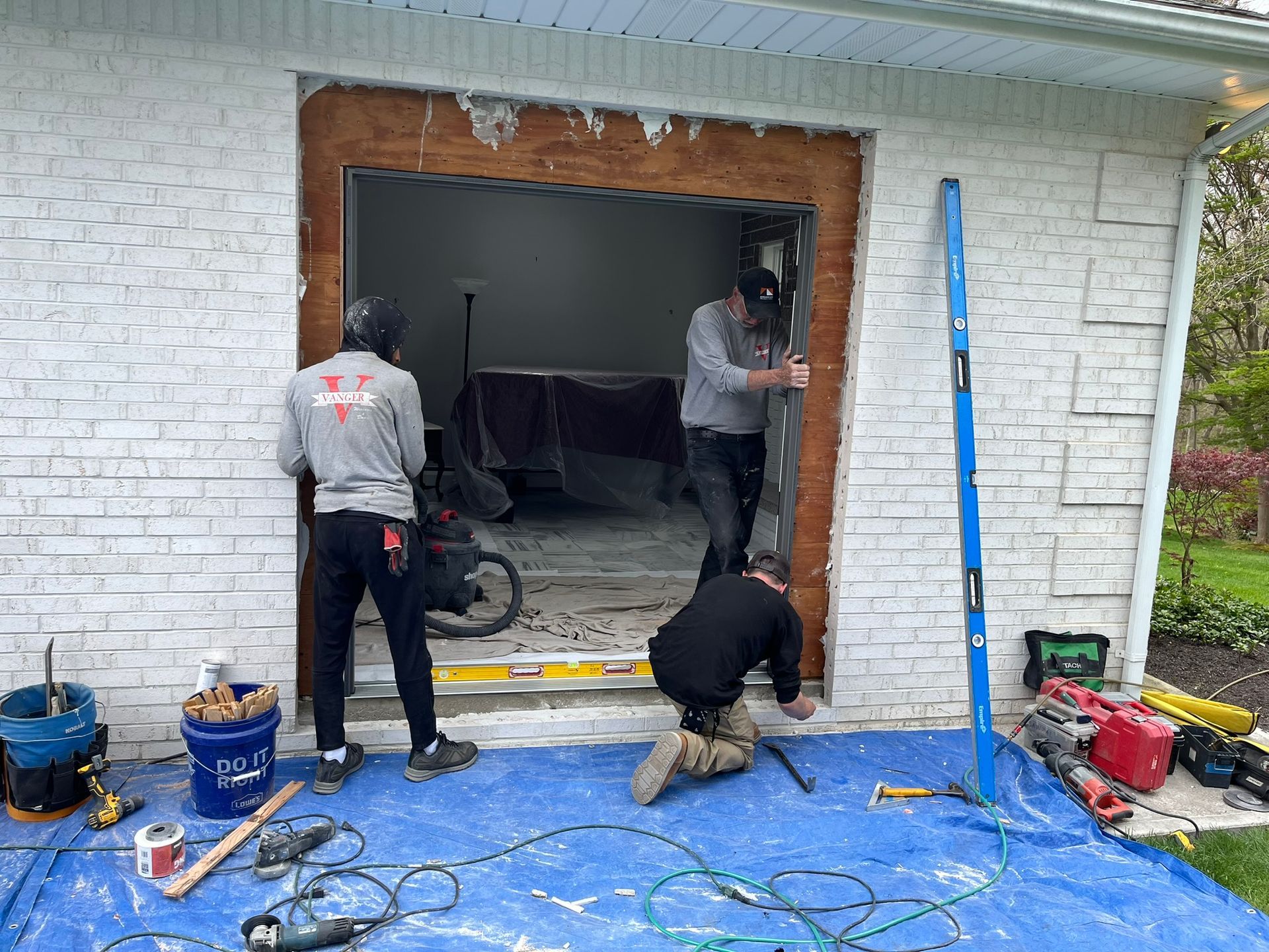 A group of men are working on a garage door.