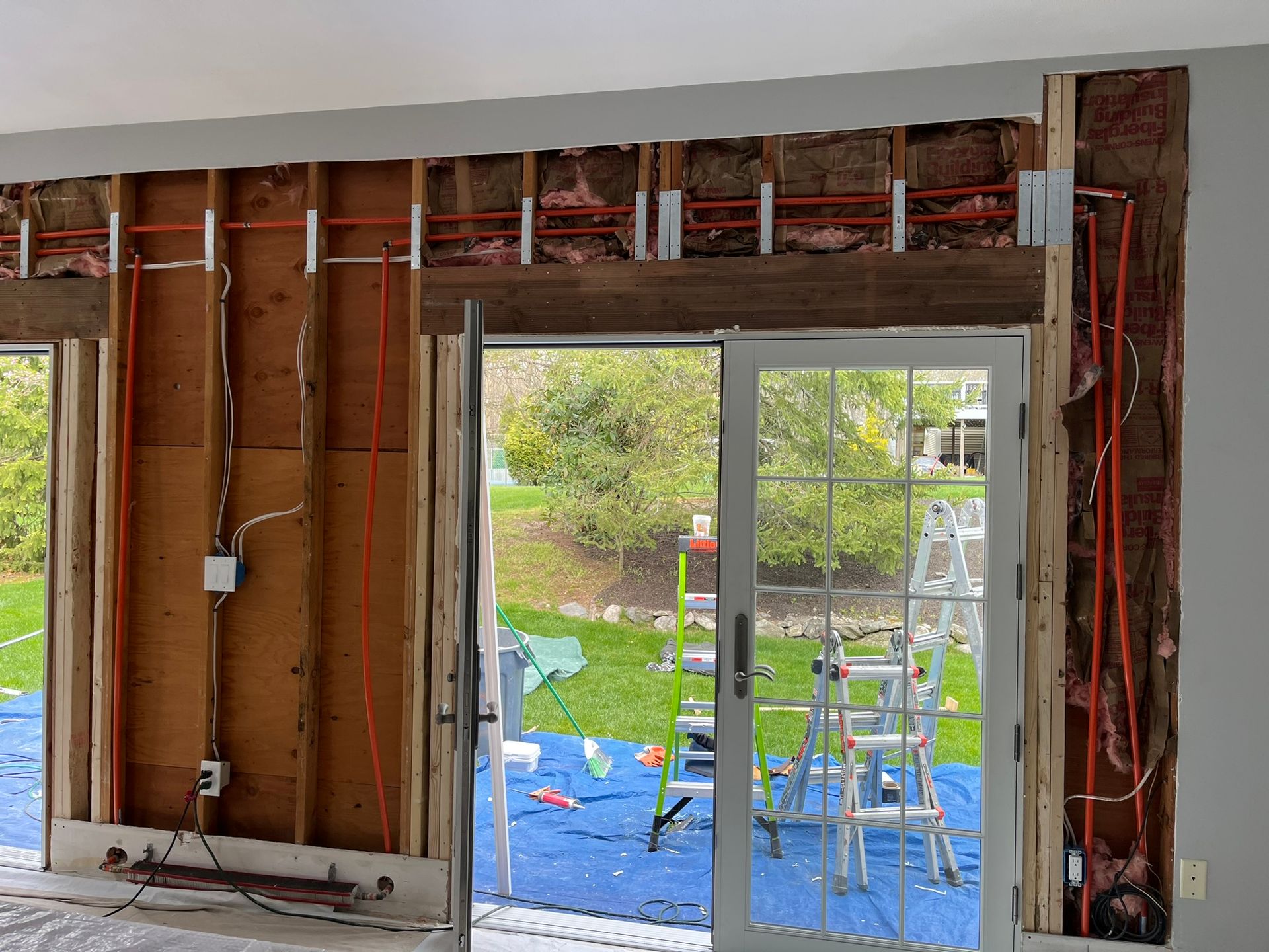 A room with a sliding glass door and a ladder.