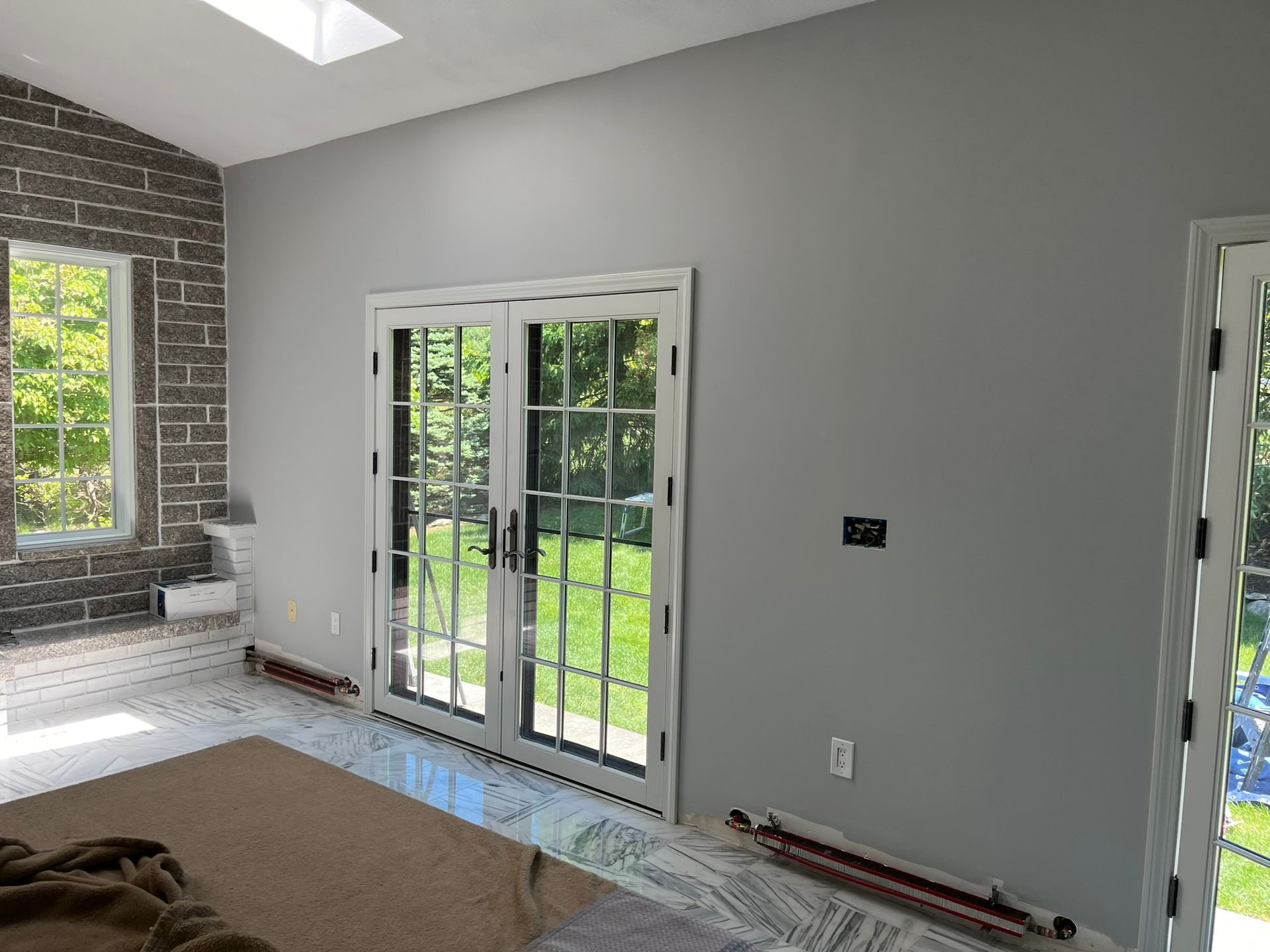 A living room with sliding glass doors and a brick wall.