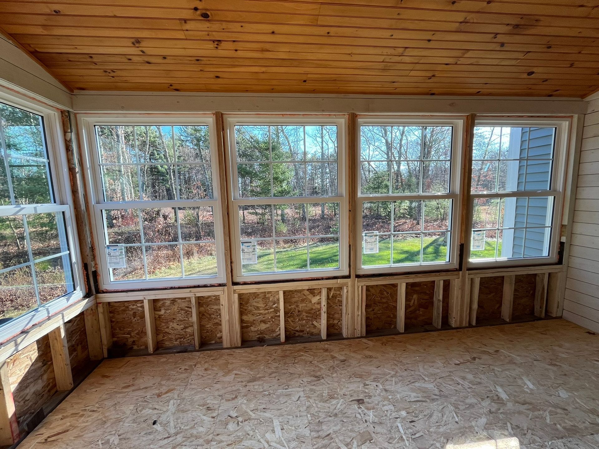 A room with a lot of windows and a wooden ceiling.