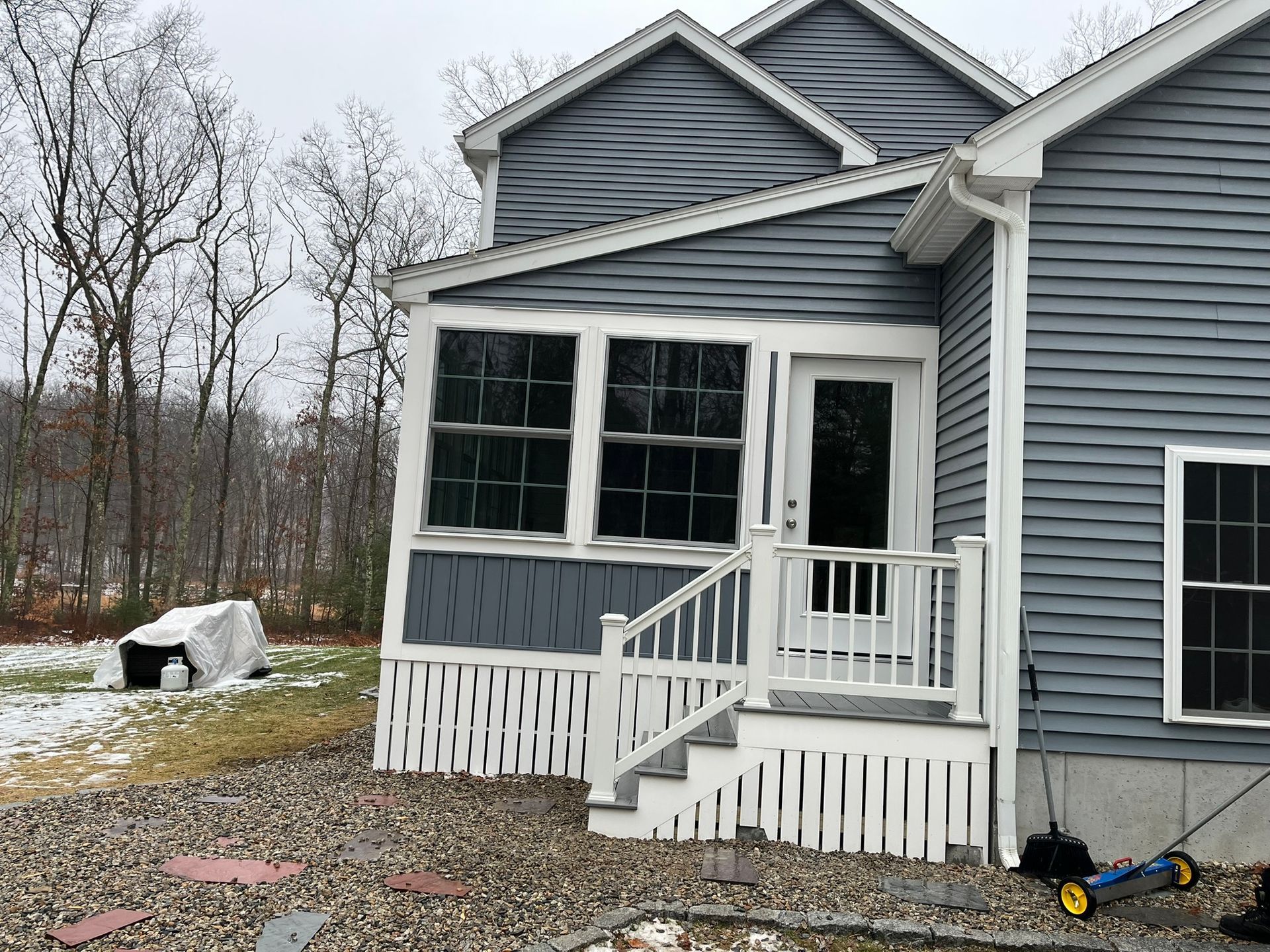 A house with a porch and stairs on the side of it.