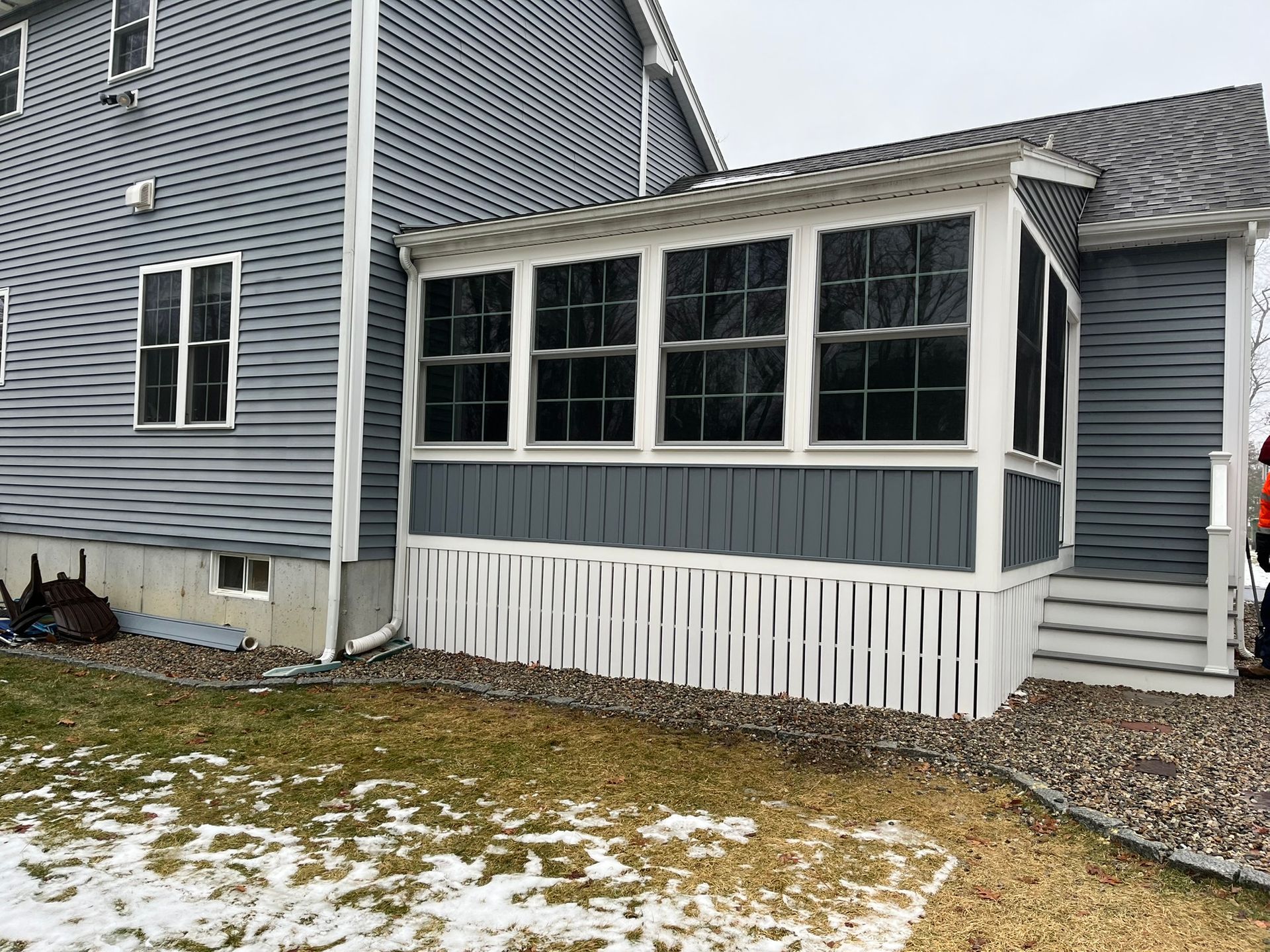 There is a screened in porch in the backyard of a house.