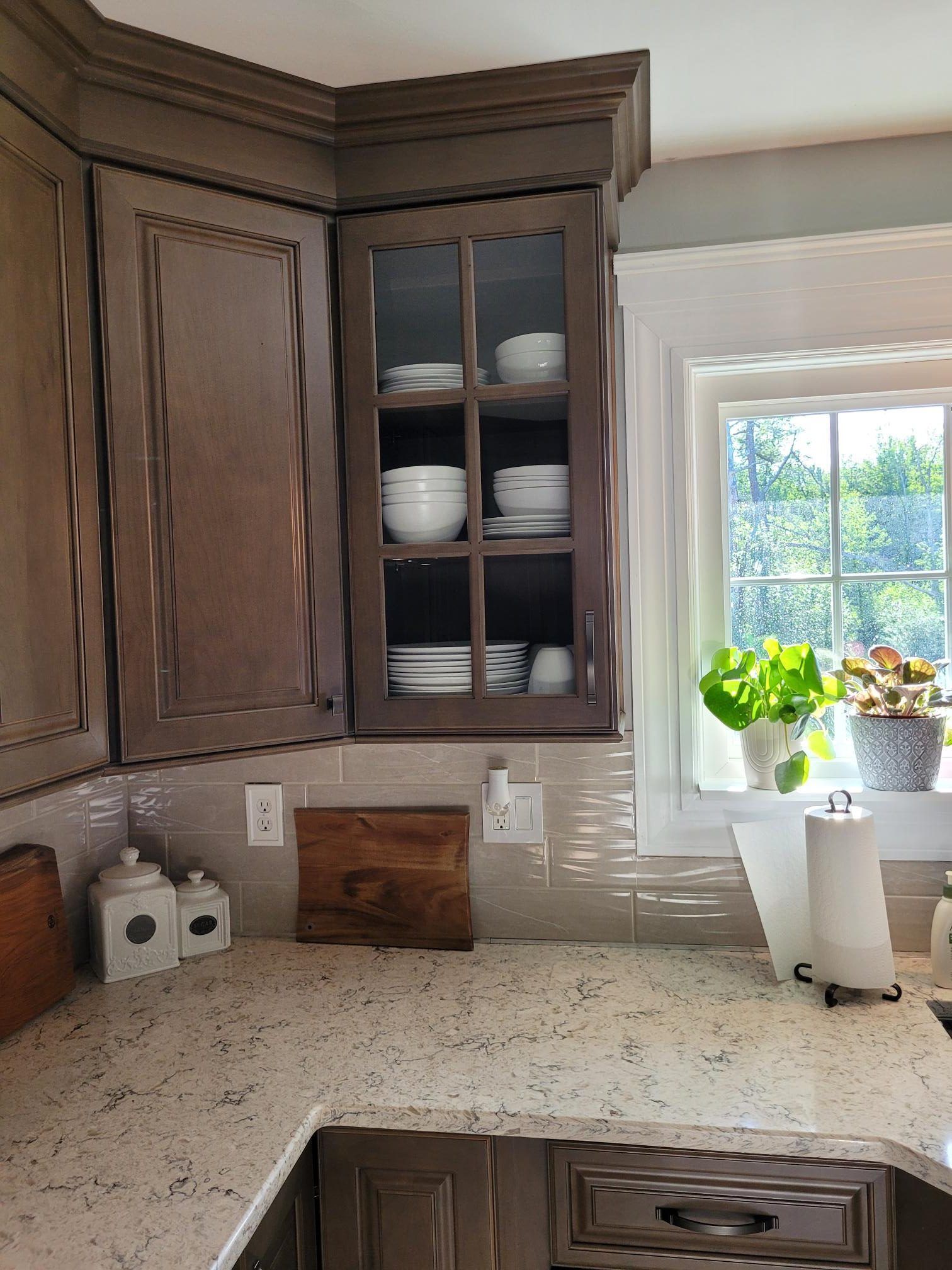 A kitchen with a sink , cabinets , and a window.