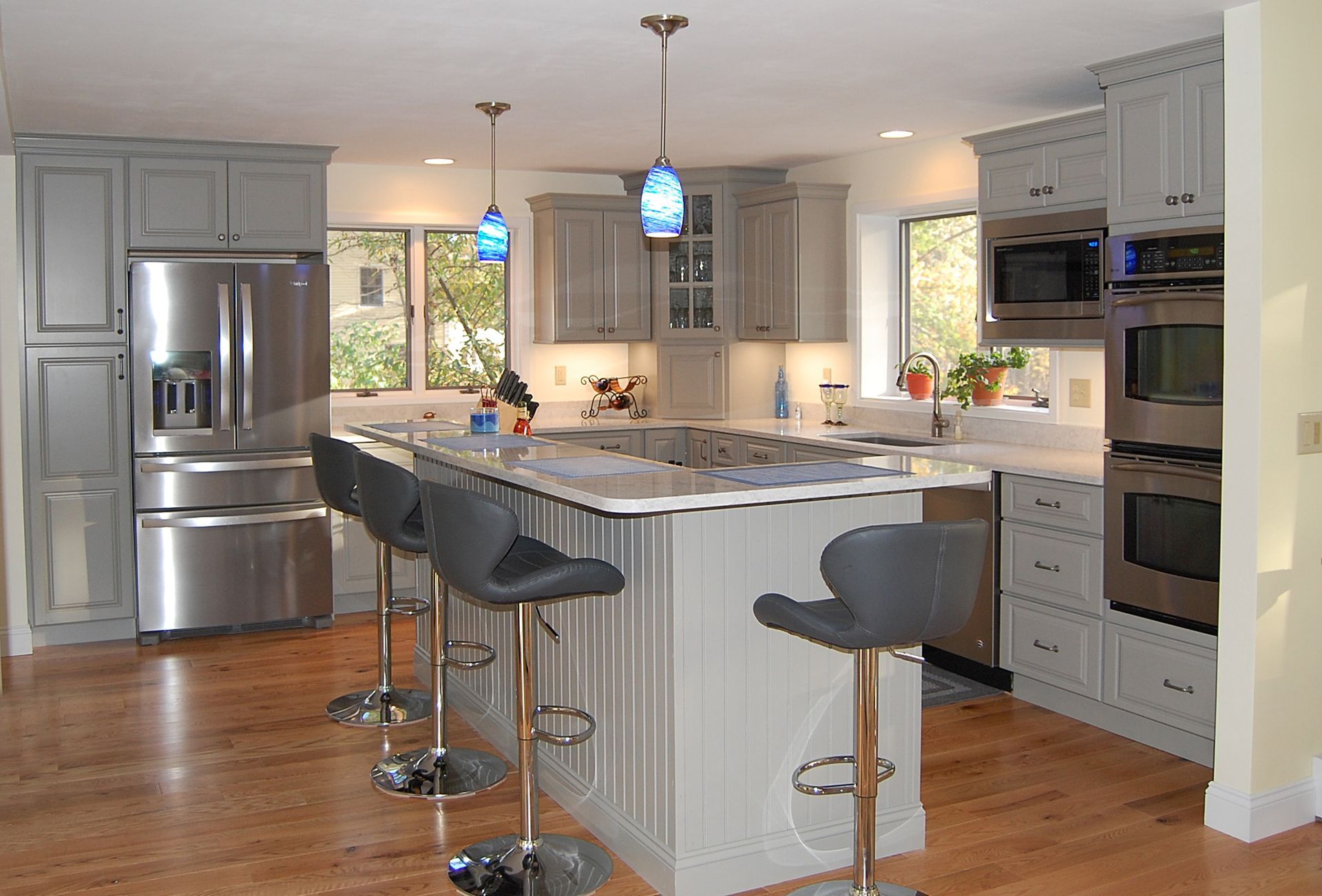 A kitchen with gray cabinets and stainless steel appliances