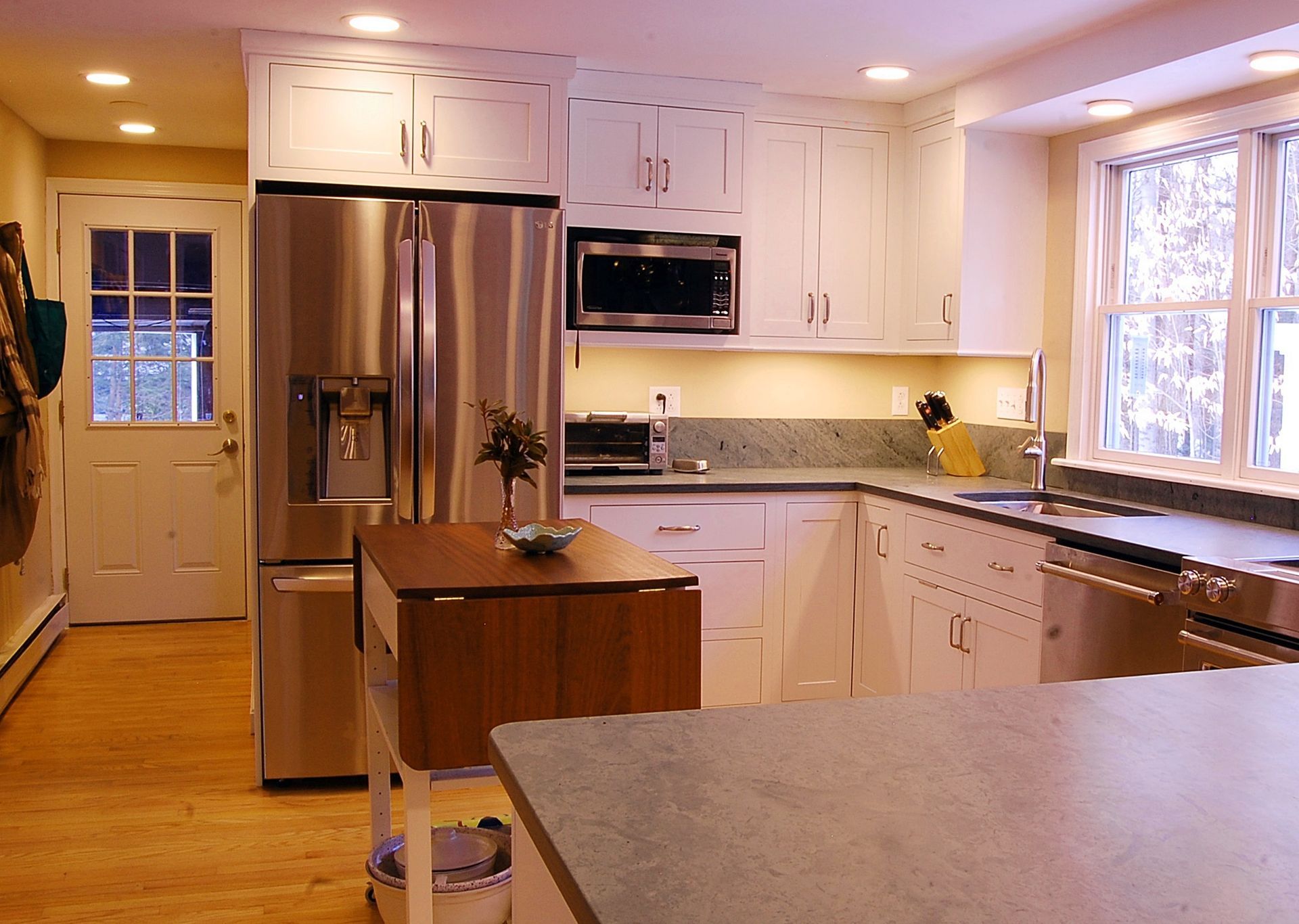 A kitchen with stainless steel appliances and white cabinets