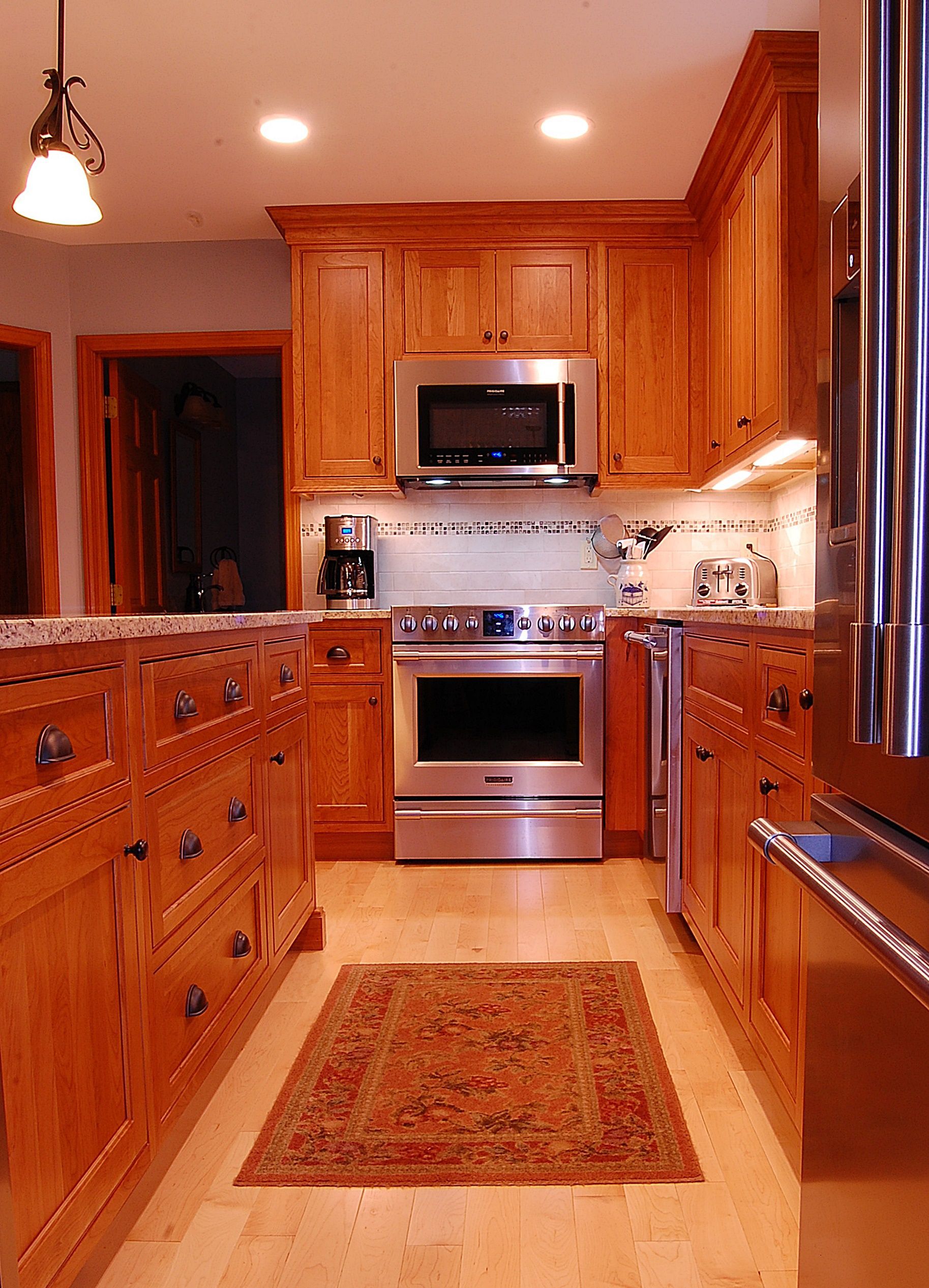 A kitchen with stainless steel appliances and wooden cabinets