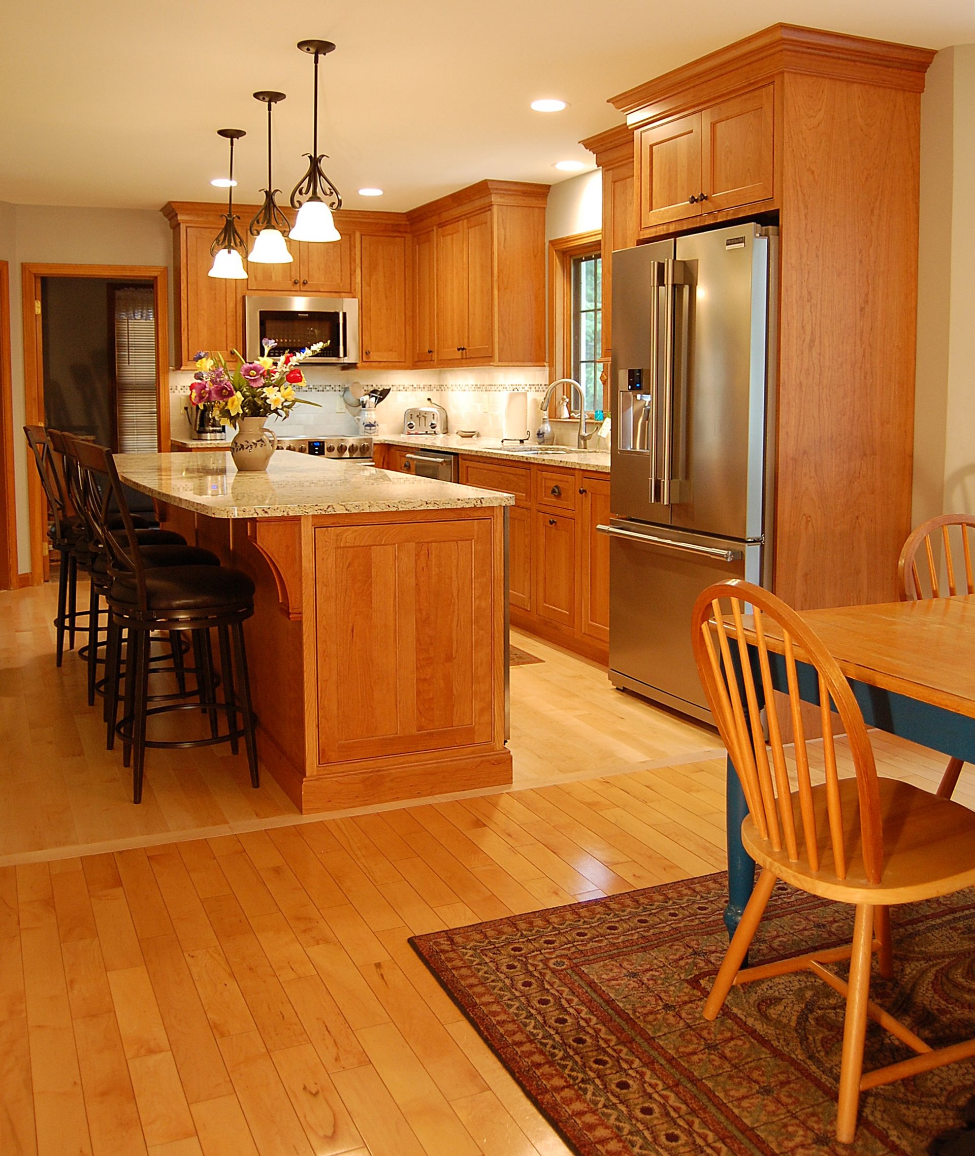 A kitchen with wooden cabinets and a stainless steel refrigerator