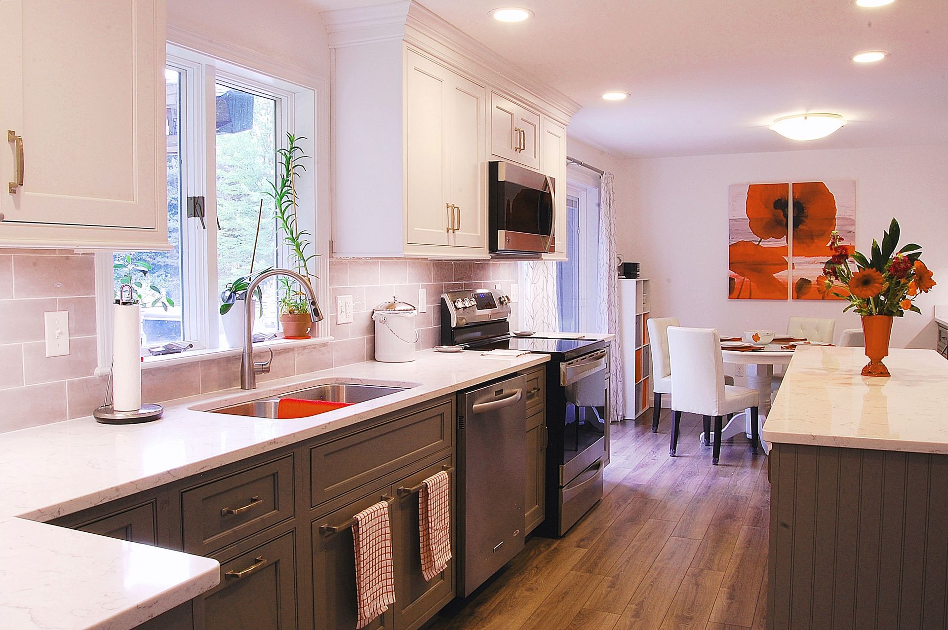 A kitchen with gray cabinets and white counter tops