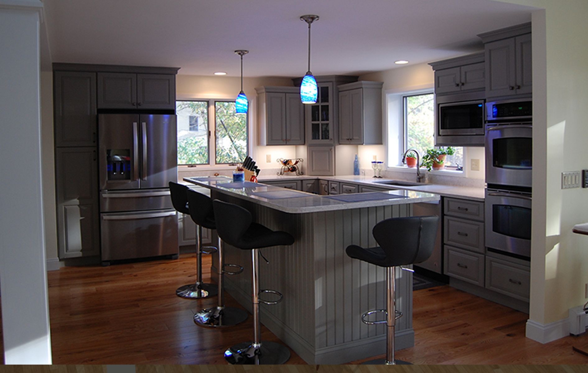 A kitchen with gray cabinets and stainless steel appliances