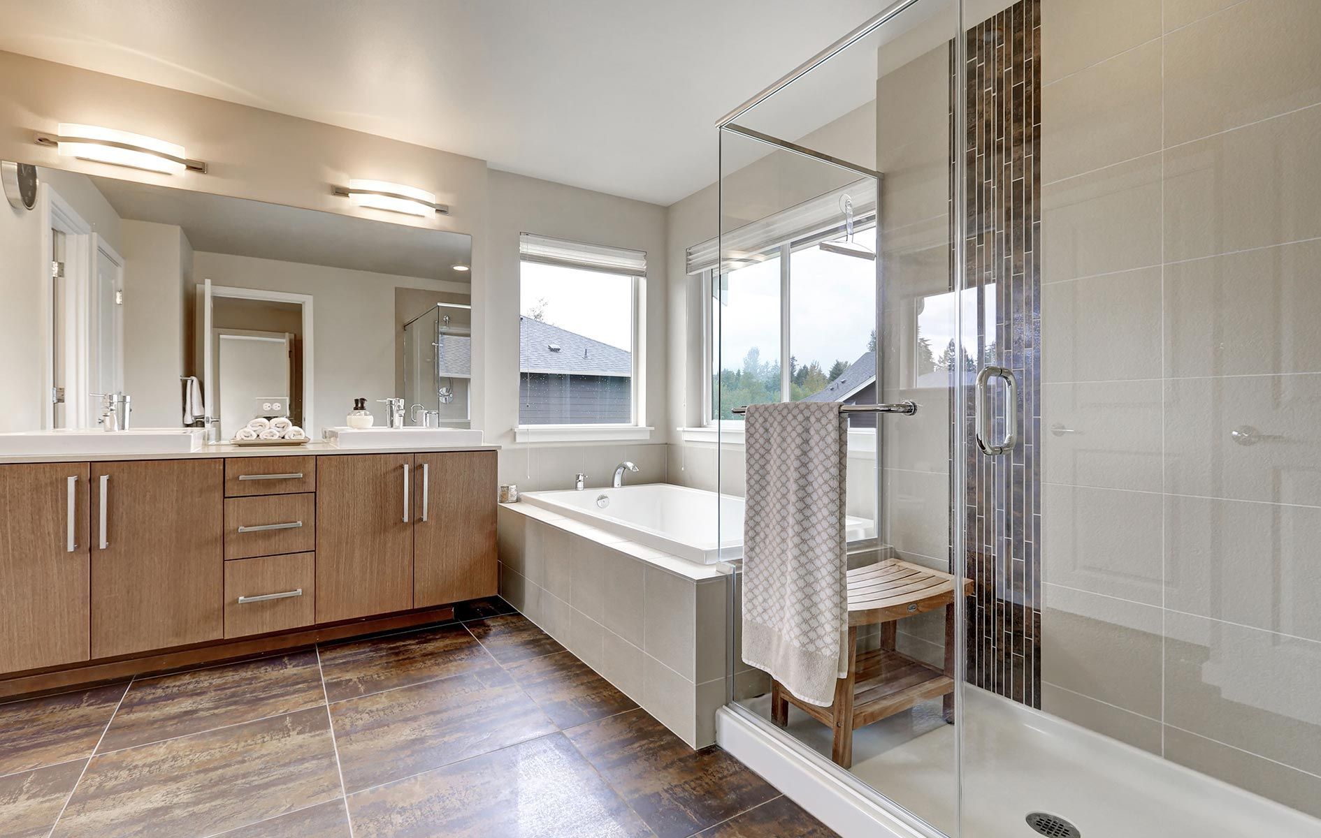 A bathroom with two sinks , a tub , and a walk in shower.