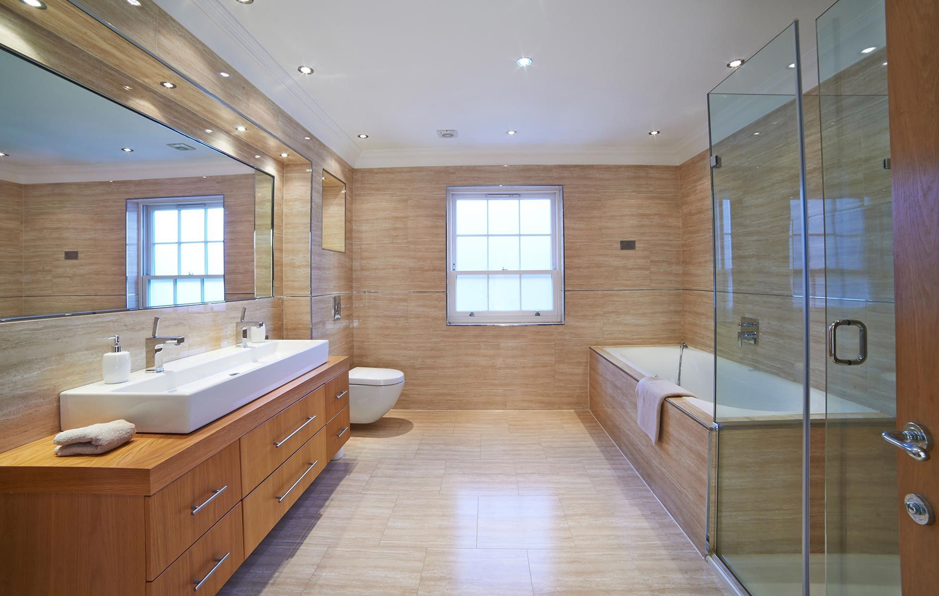 A bathroom with two sinks , a toilet , a bathtub and a walk in shower.