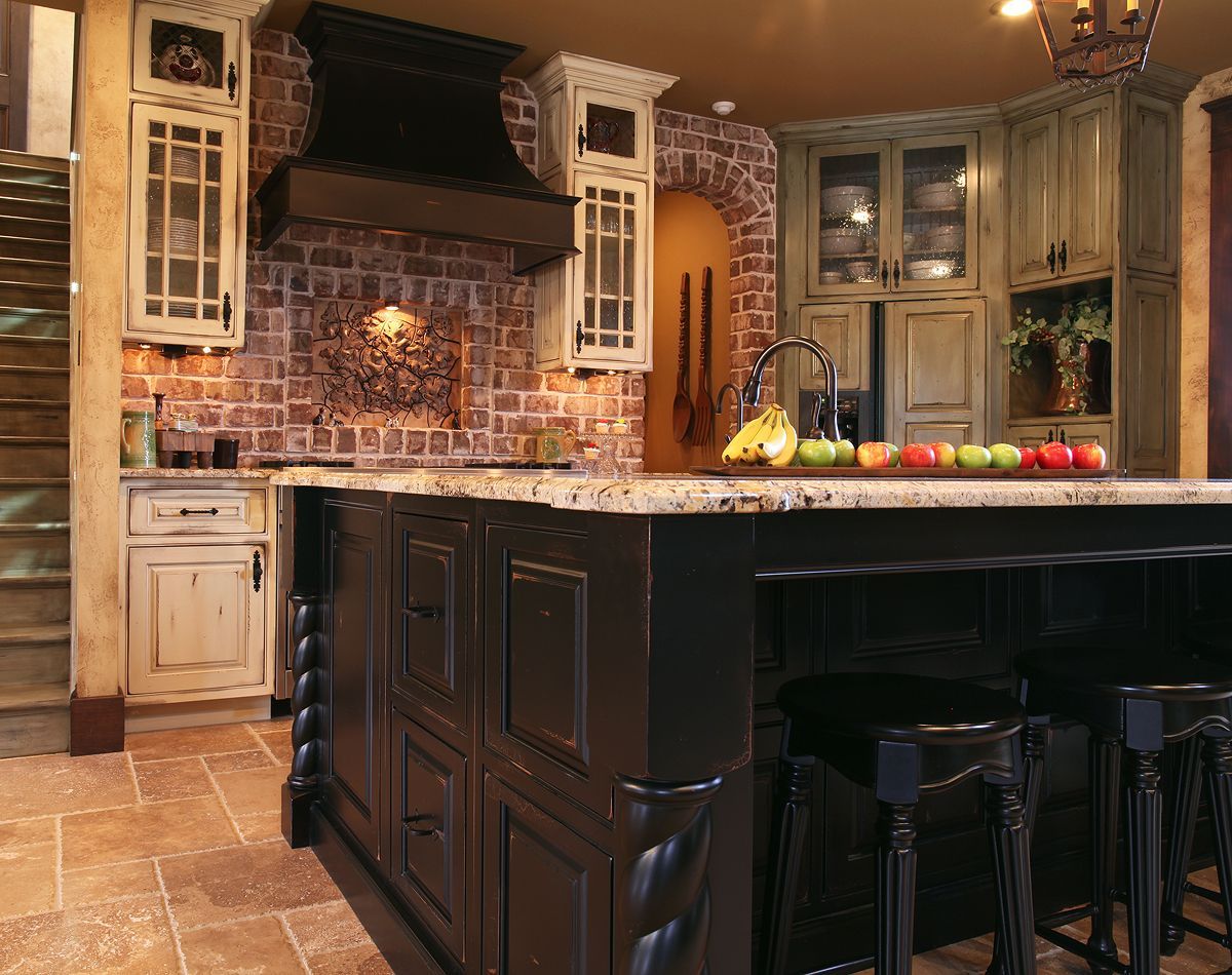 A kitchen with black cabinets and a large island with fruit on it