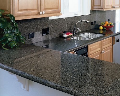 A kitchen with granite counter tops and wooden cabinets