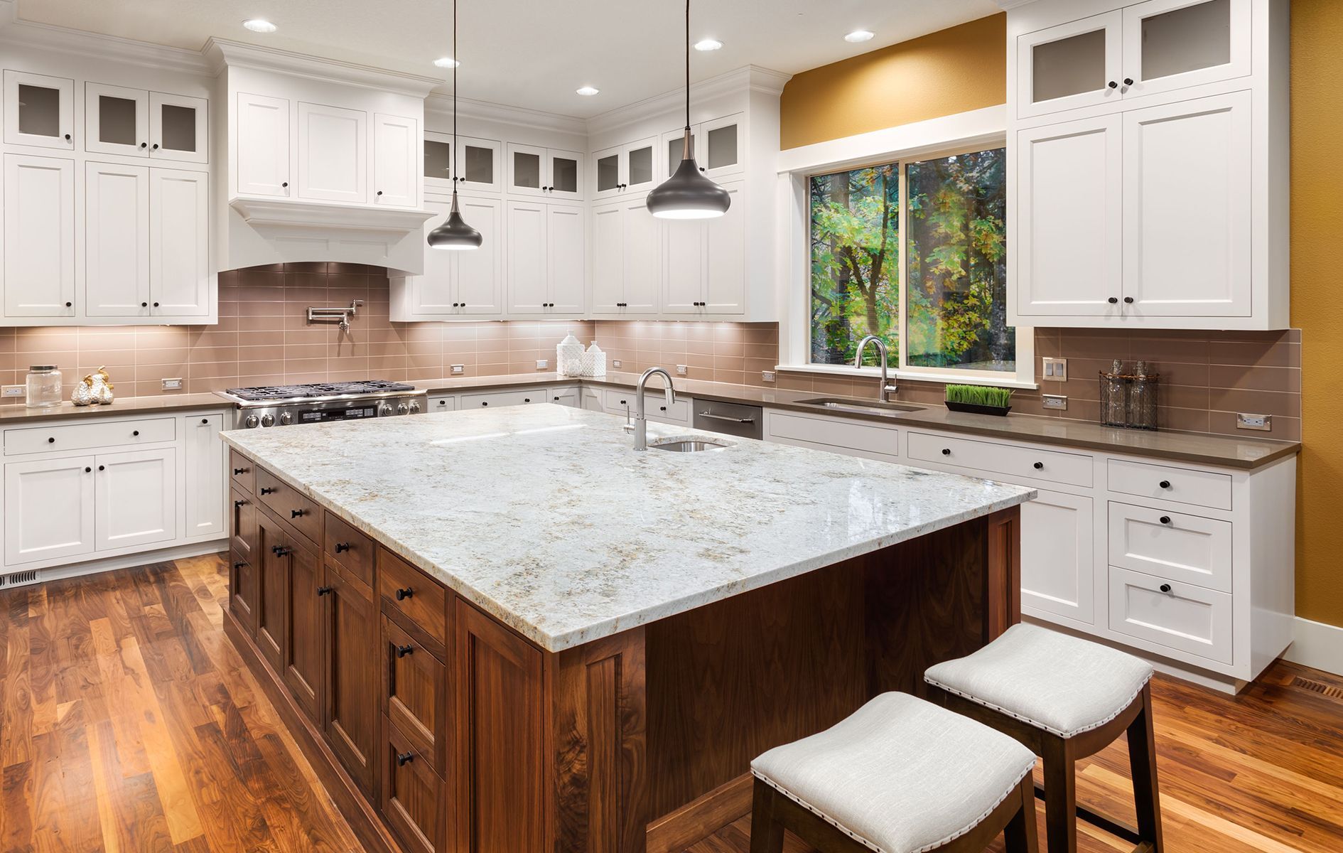 A kitchen with white cabinets and a large island in the middle.