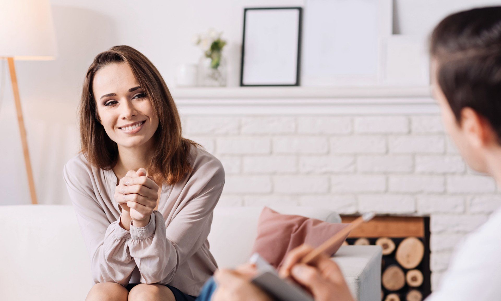 A woman is sitting on a couch talking to a man.